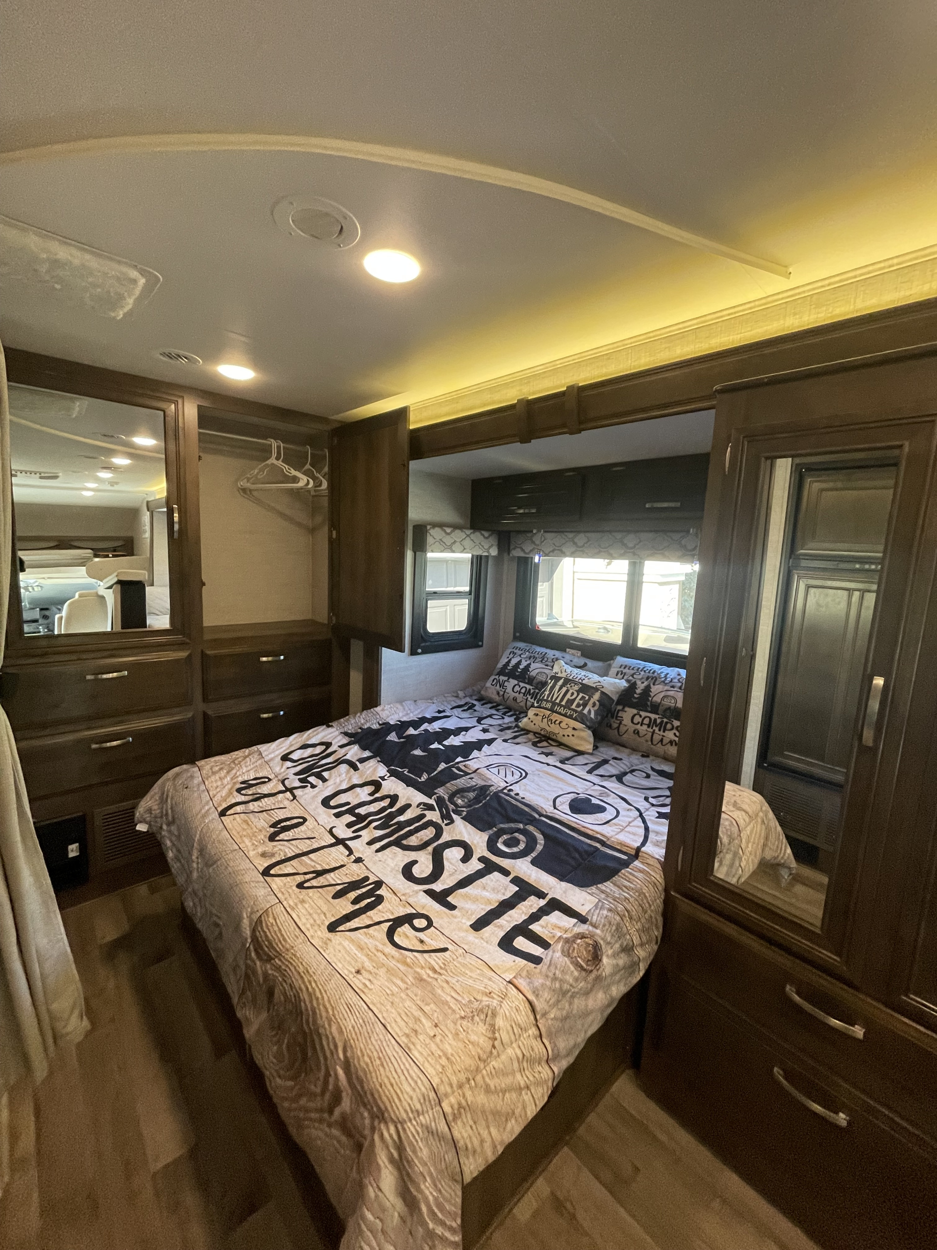 Comfortable RV rental bedroom with camp-themed bedding, built-in storage, and ambient lighting.. Jayco Redhawk 2021