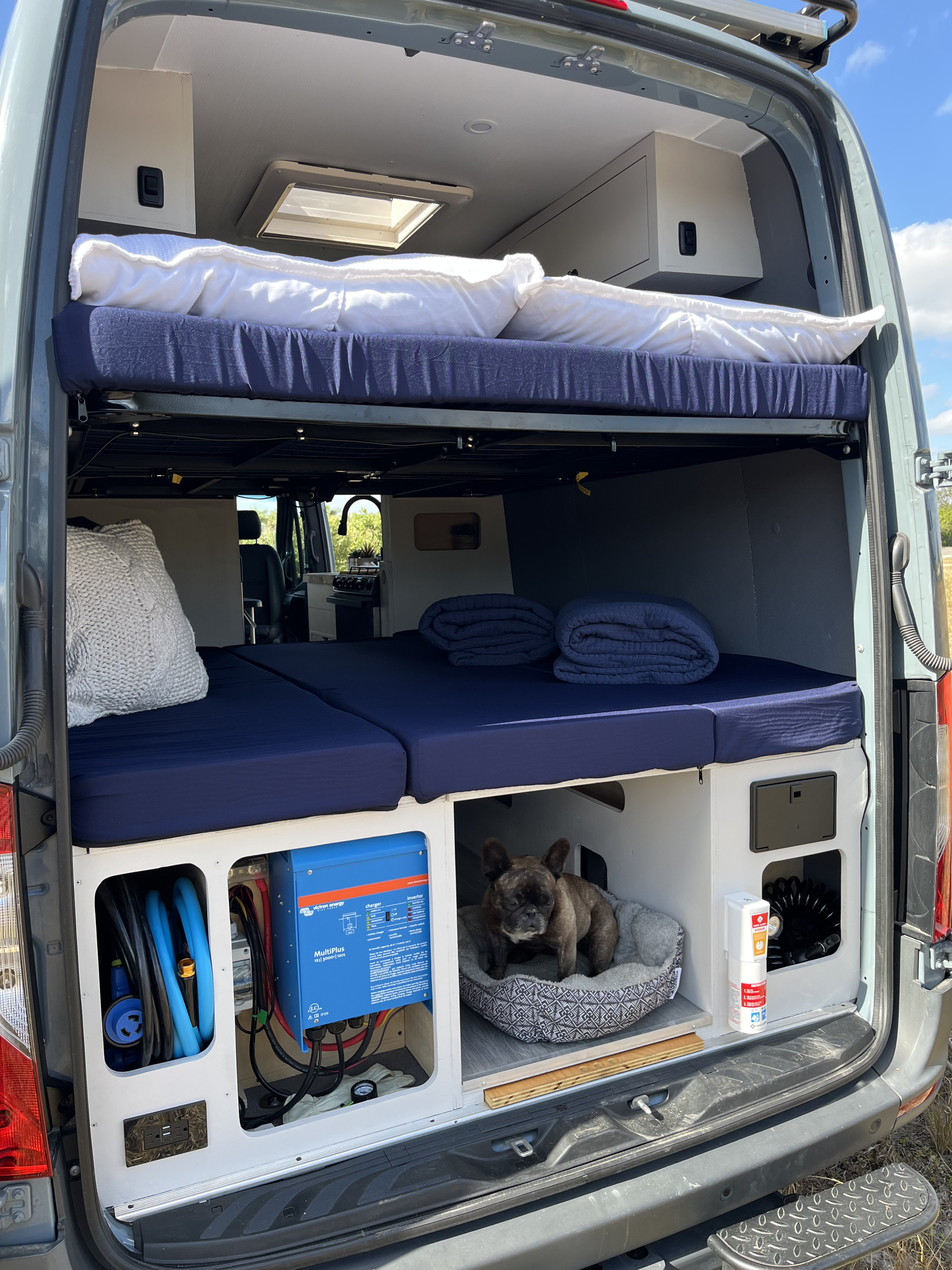 Spacious RV rental camper van interior with bunk beds, custom storage, power system, and a dog's cozy corner.. Mercedes benz Sprinter 2022