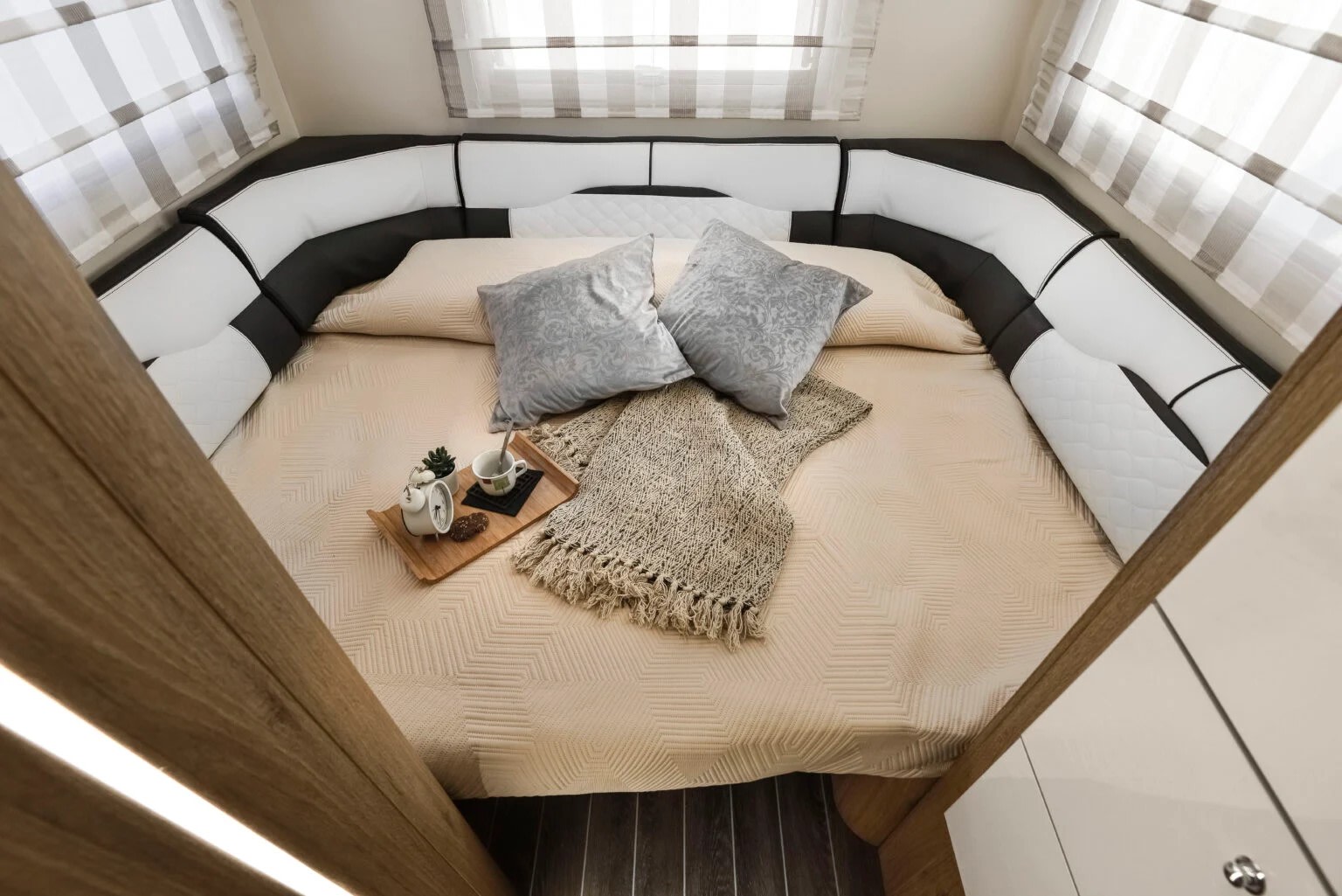 Inside a premium rv rental: a welcoming bedroom with a large bed, wrap-around seating, and a thoughtful breakfast setup.. Roller Team Auto-Roller 746 2025