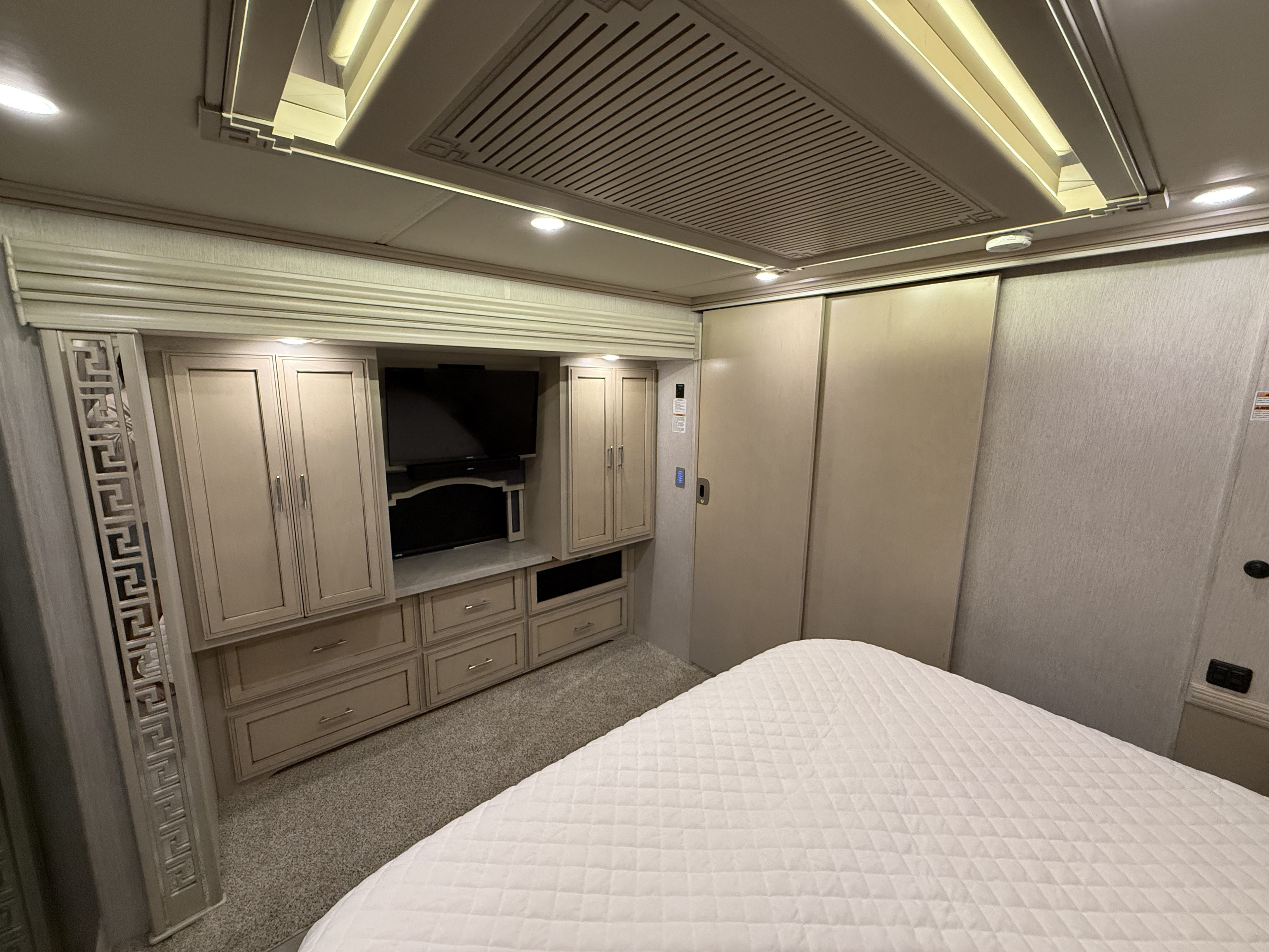 RV rental bedroom featuring a comfortable bed, built-in cabinetry, and TV. A cozy interior for your journey.. Newmar Ventana 2020