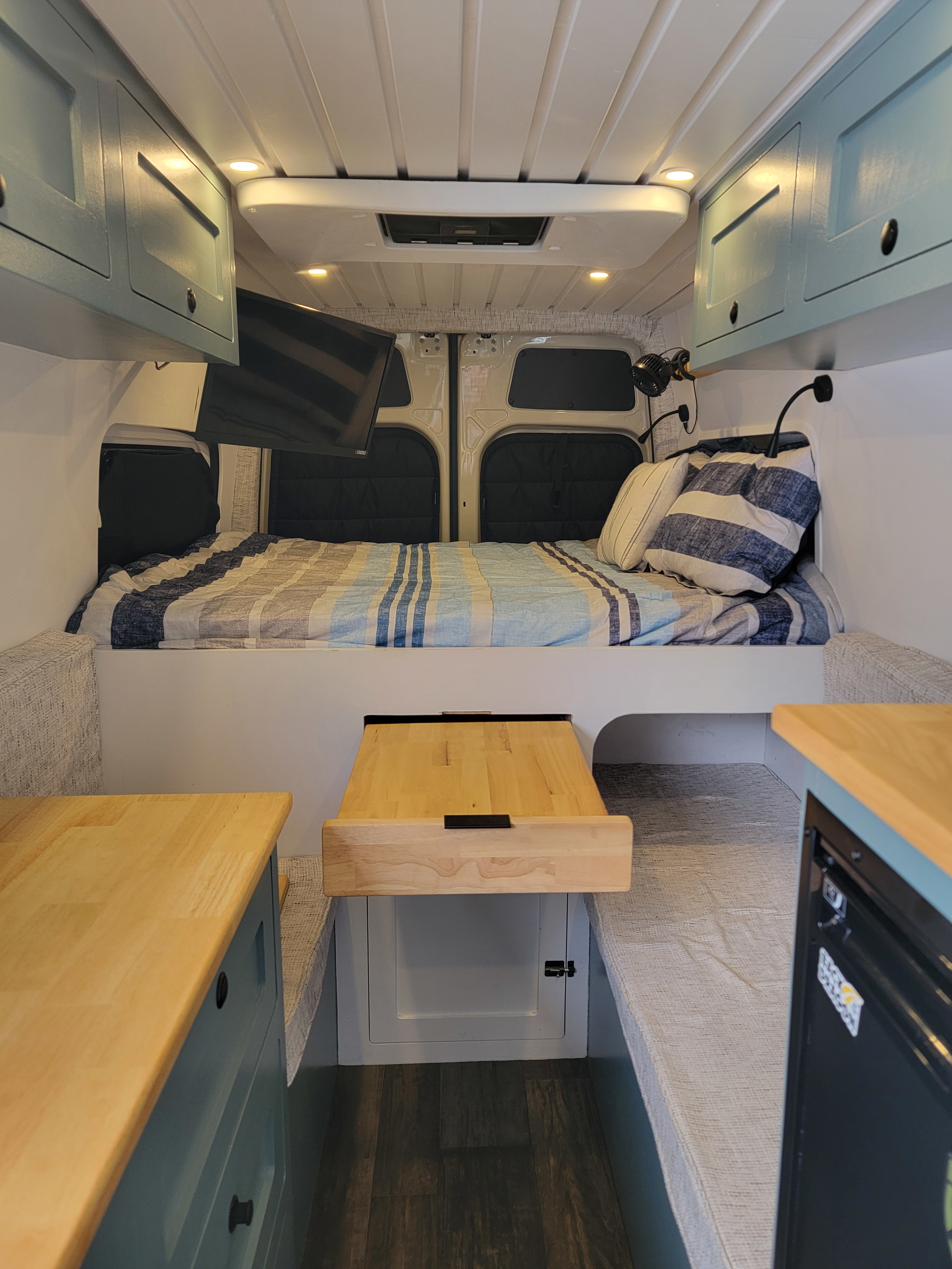 RV rental: well-designed camper van interior with bed, built-in cabinets, pull-out table, and cozy bench seating.. Mercedes-Benz Sprinter 2022