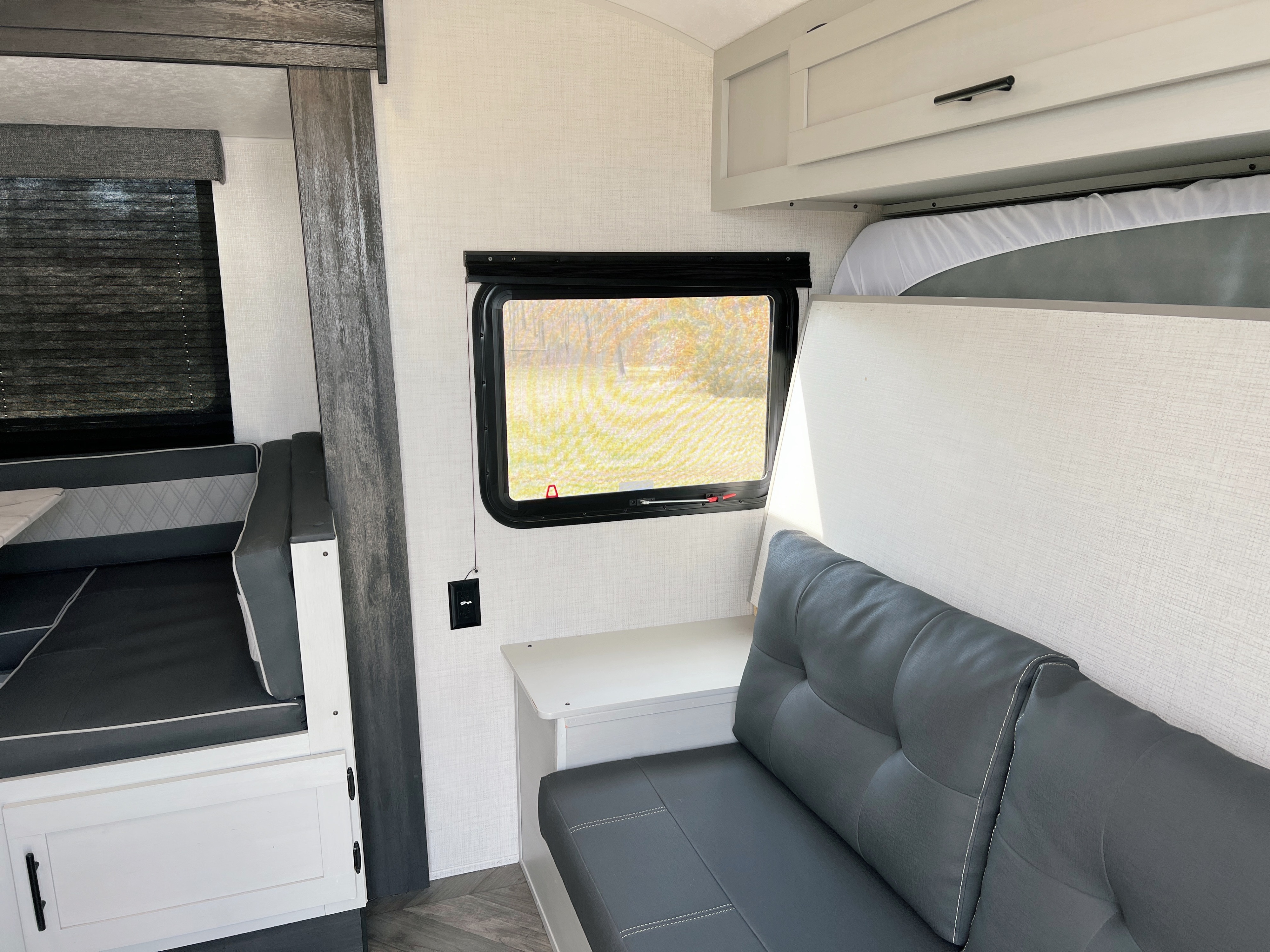 Spacious rv rental interior with a cozy dinette, window view, and versatile bunk bed over comfortable seating.. Forest River Salem FSX 2022