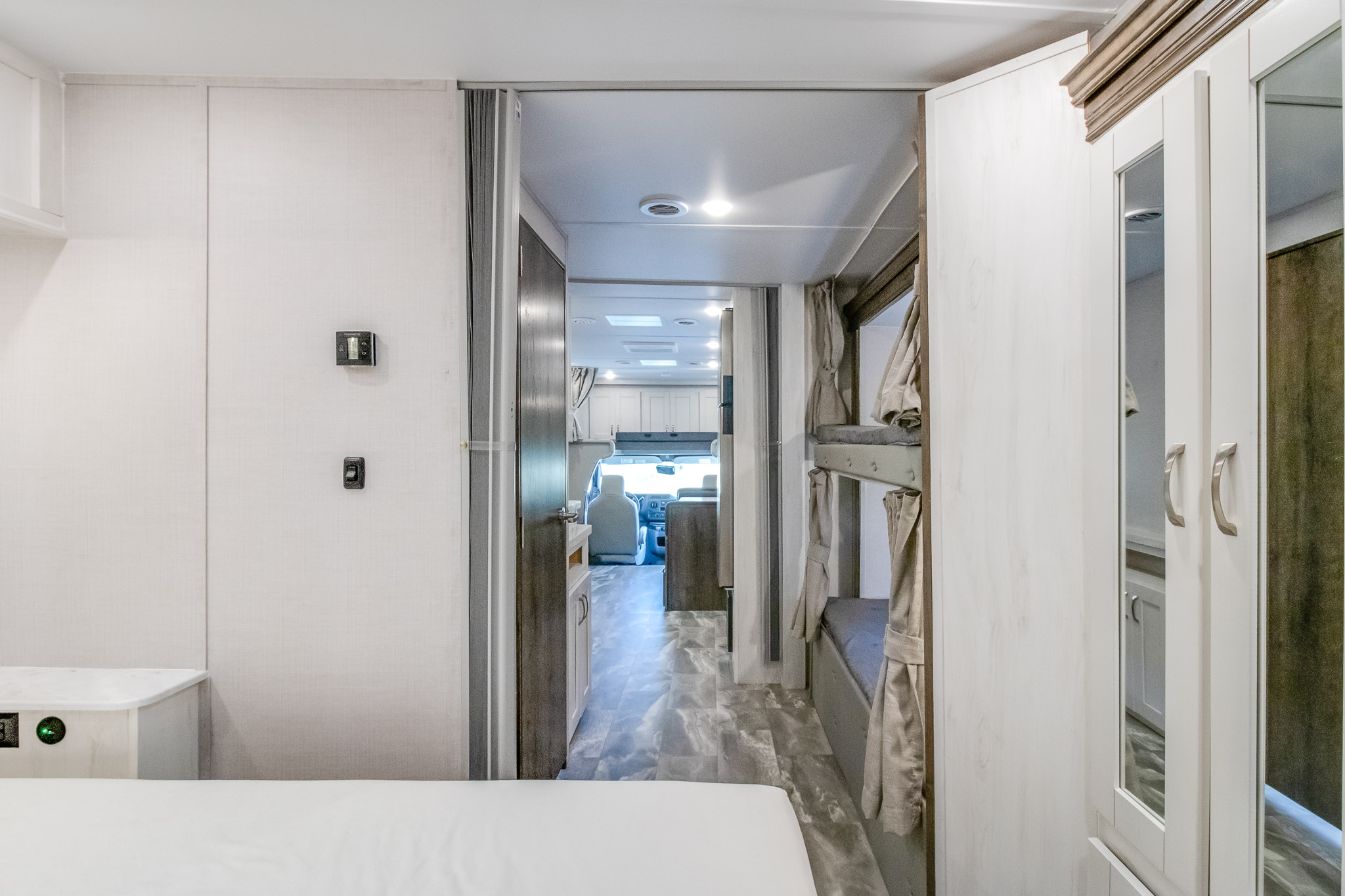 This modern RV rental interior features bunk beds, a bedroom, and a hallway leading to the kitchen and driver's cockpit.. GULFSTREAM CONQUEST 2025
