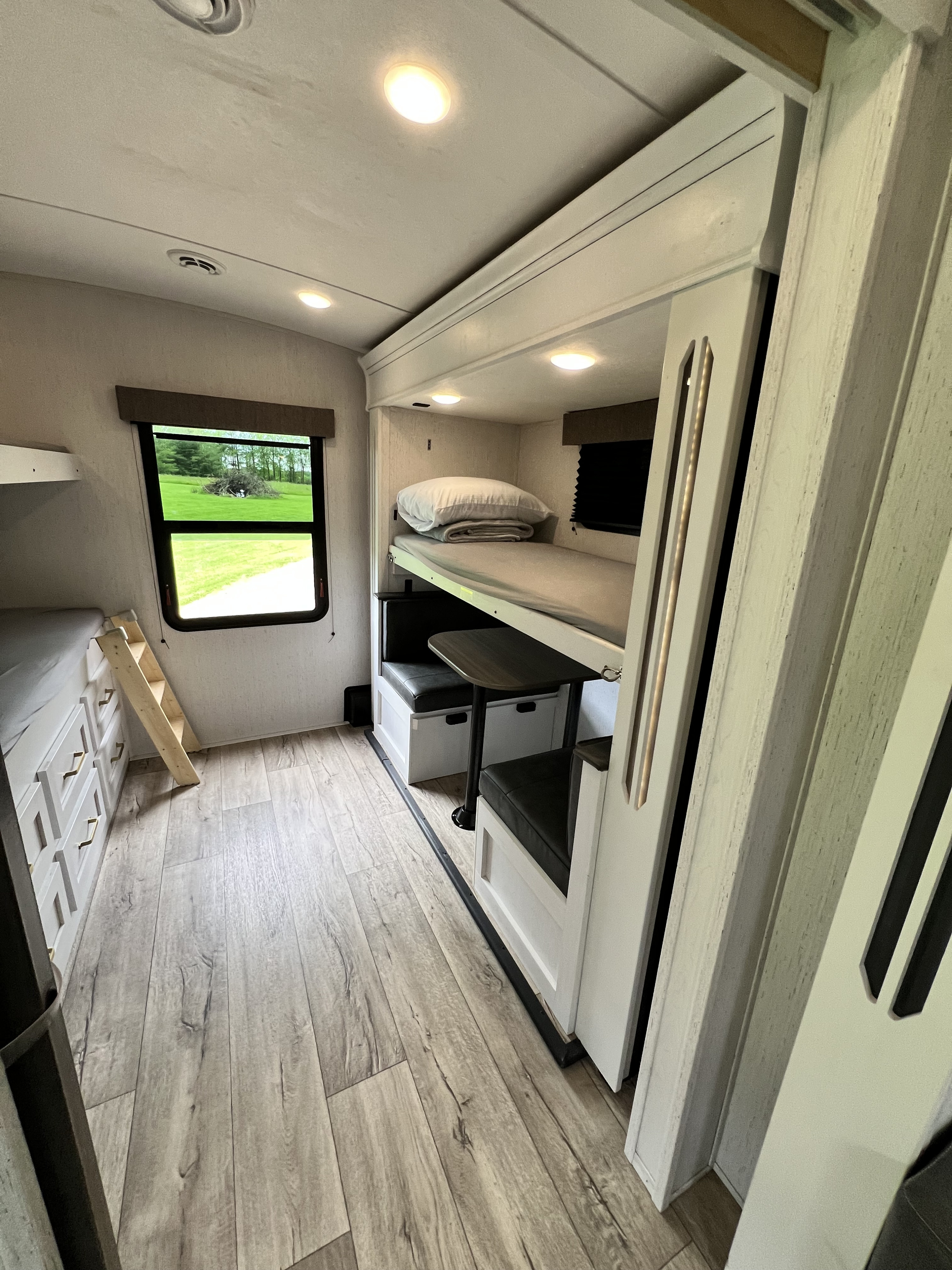 Spacious RV rental interior featuring bunk beds, a dinette, and bright, modern decor. Perfect for family adventures.. Dutchmen Astoria 3203BH 2022