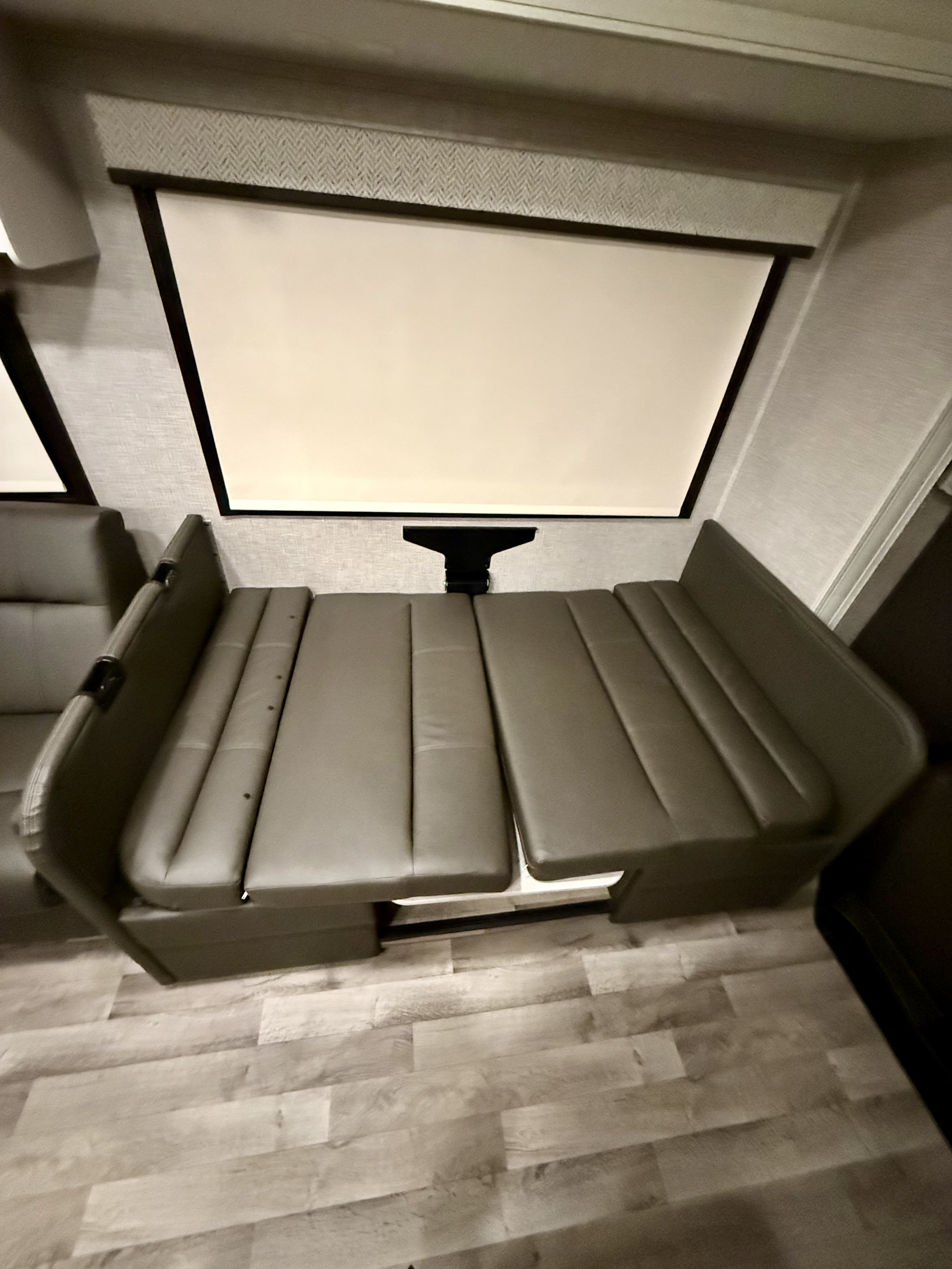 Spacious RV rental dinette converts to a comfy bed. Enjoy movie nights with the built-in screen!. Jayco Greyhawk 2023