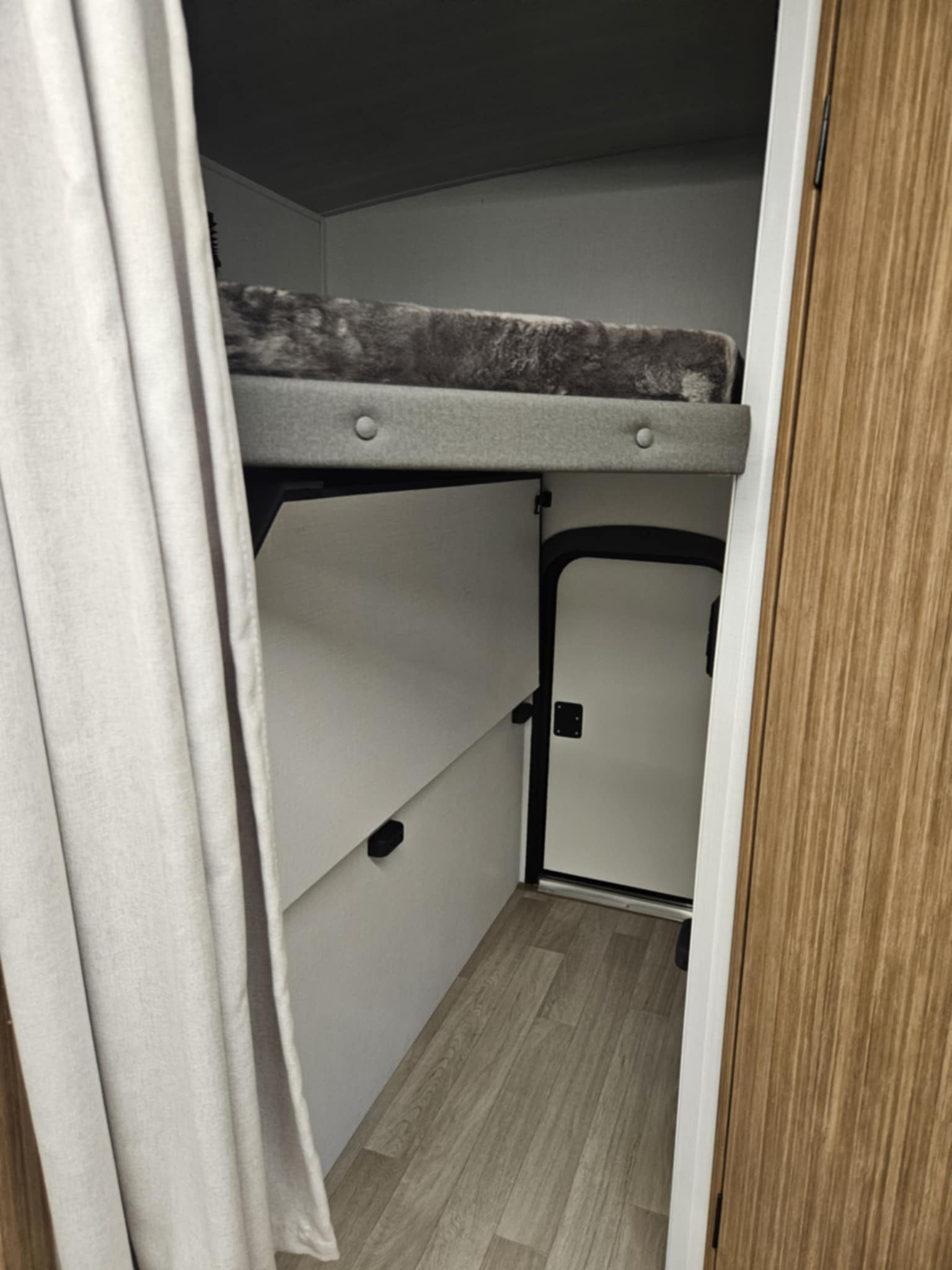 RV rental interior: cozy bunk bed area with a lower access door, ideal for compact travel.. Keystone RV Passport SL 2025