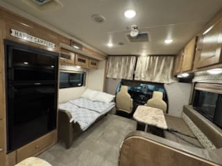 Inside your rv rental: a comfortable interior with a bed, dinette, and kitchen ready for happy campers.. Coachmen Leprechaun 2020
