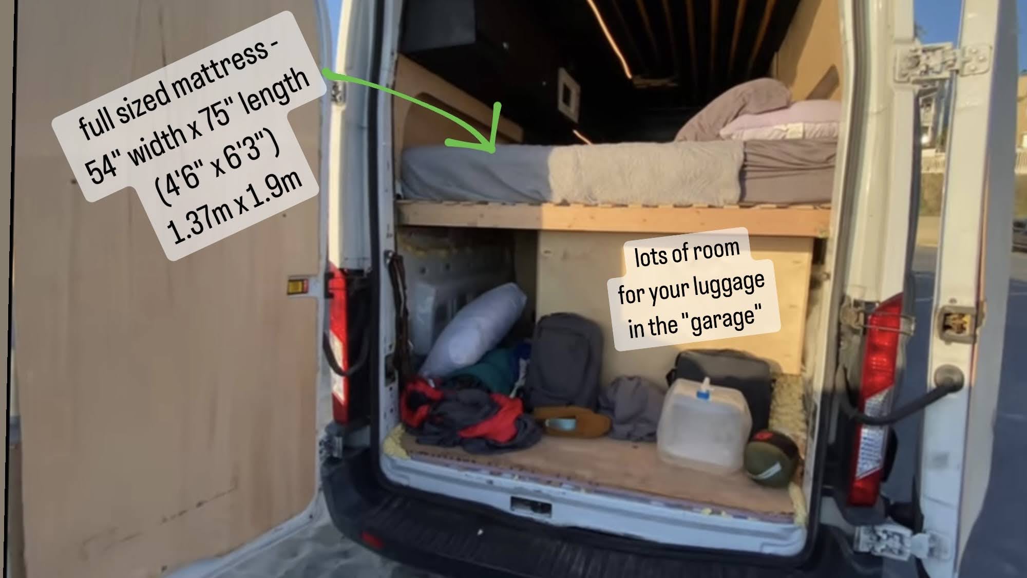 Inside your rv rental: A cozy full-size mattress (54"x75") over ample 'garage' storage for your adventures.. Ford Transit 2015