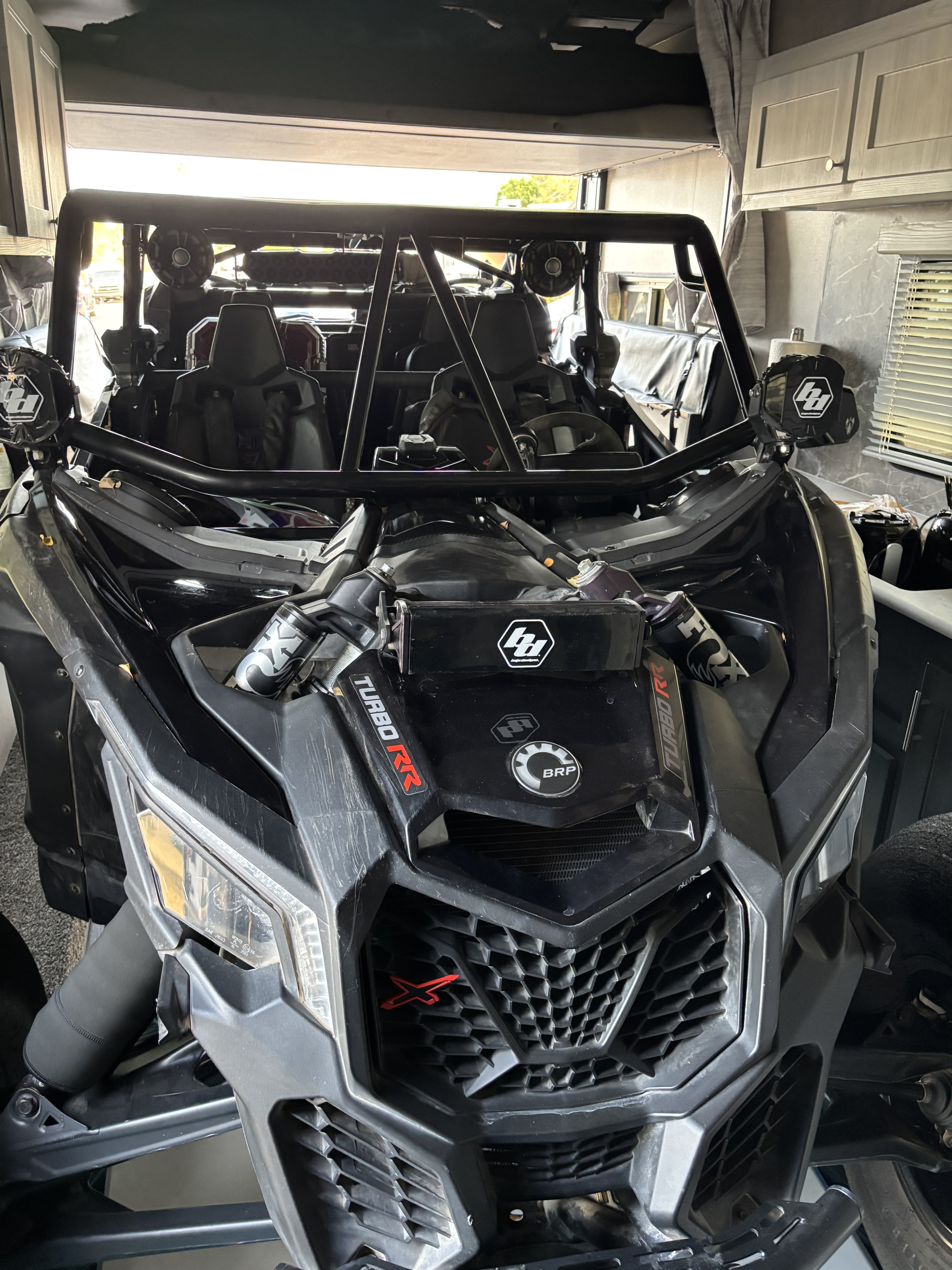 A black Can-Am Maverick Turbo RR UTV loaded in a toy hauler RV garage, ideal for an RV rental adventure.. Eclipse Recreational Vehicles Iconic 2024