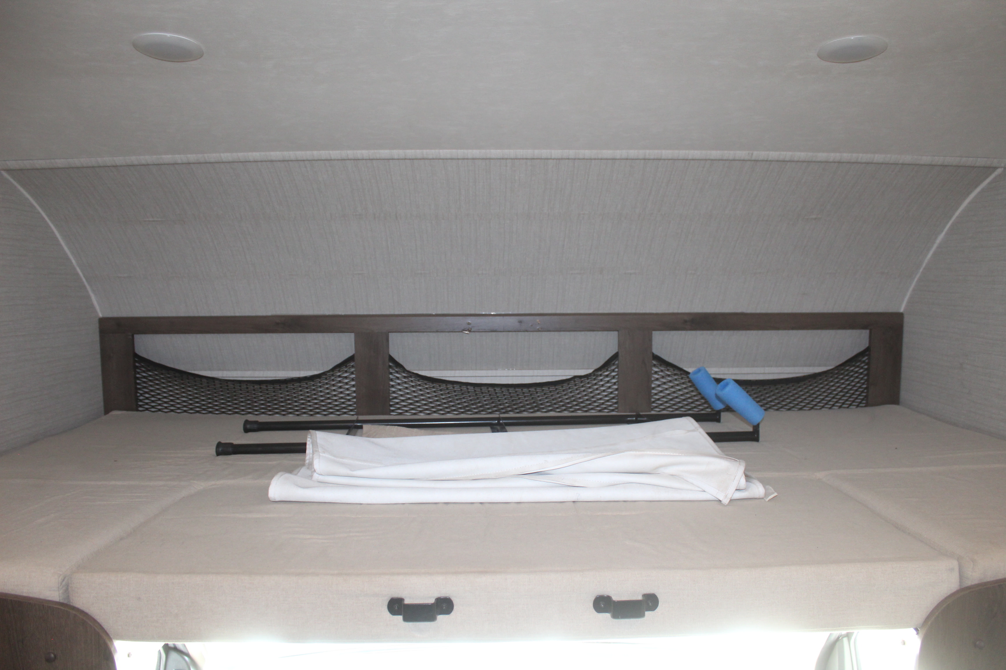 Comfortable overhead bed in an RV rental, featuring mesh storage nets and a soft mattress for travel.. Jayco Redhawk 2019