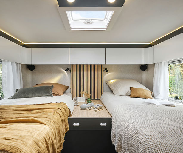 RV rental: inviting bedroom with two comfortable beds, central table, ample storage, skylight, & warm ambiance.. Pilote G740FGJ 2025