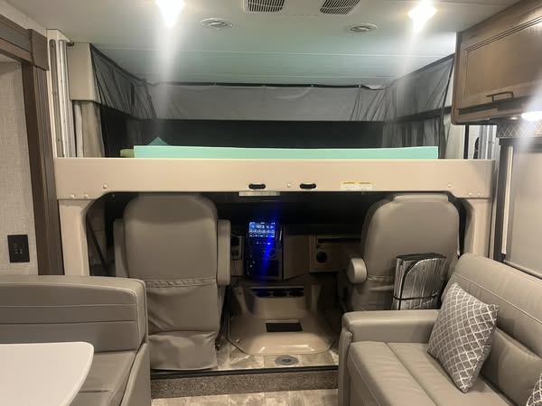 RV rental interior: cozy bunk bed above the cab area, with comfortable living space and an accent pillow.. Thor Motor Coach Windsport 2022