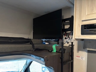 Spacious RV rental cab-over bunk with a large mounted TV, providing onboard entertainment for your next adventure.. Forest River Sunseeker LE 2022