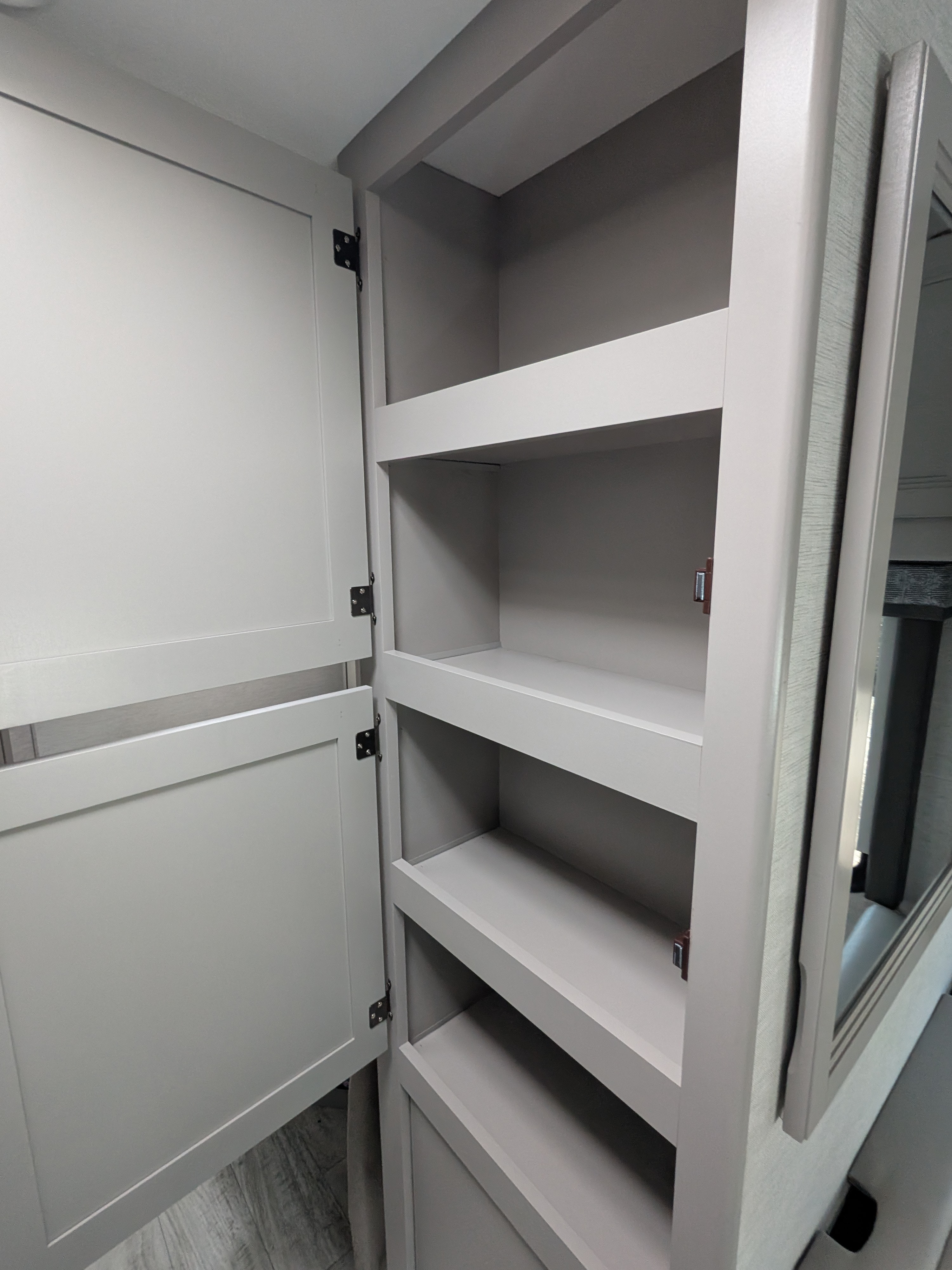 RV rental interior: open gray storage cabinet with multiple shelves, perfect for organized travel.. Thor Motor Coach Chateau 2025