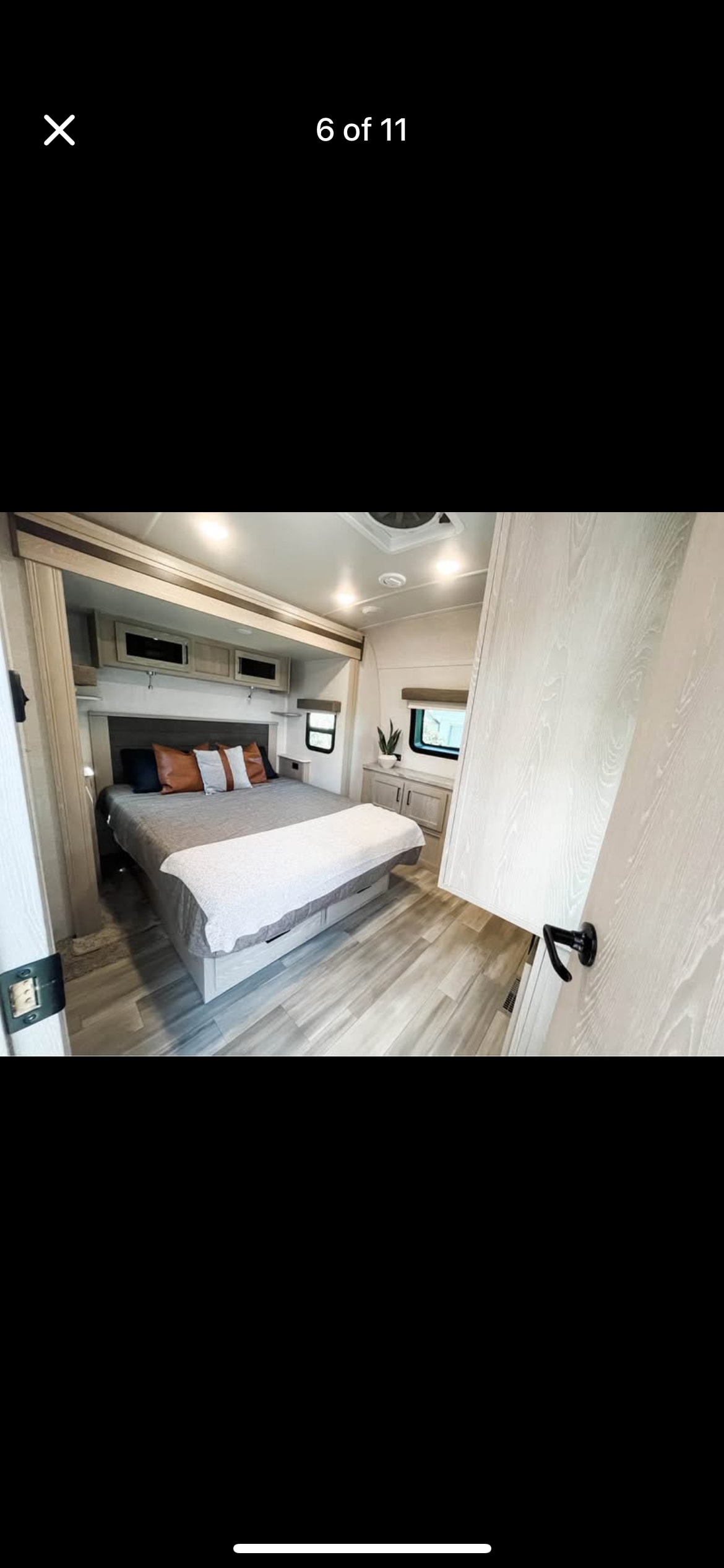 Bright, modern RV rental bedroom with cozy bed, light wood interior, and ample storage.. Forest River Rockwood Signature 2021
