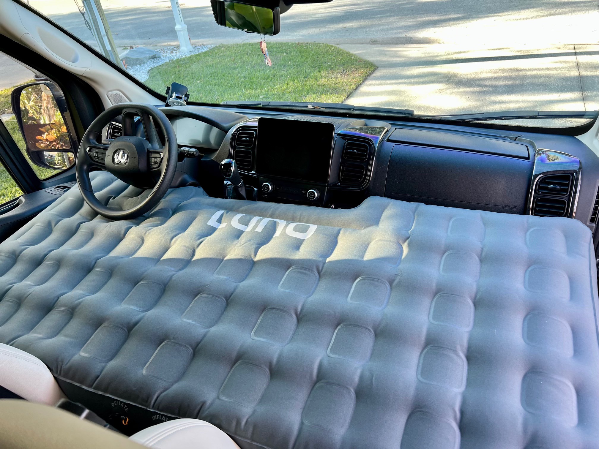 An inflatable air mattress transforms this RV rental's front cabin into a comfortable sleeping setup, ideal for van camping trips.. Winnebago Travato 2023