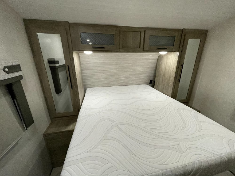 Experience comfort in this well-appointed RV rental bedroom, featuring a new mattress, overhead storage, and mirrored wardrobe.. Forest River Salem Hemisphere HL 2022