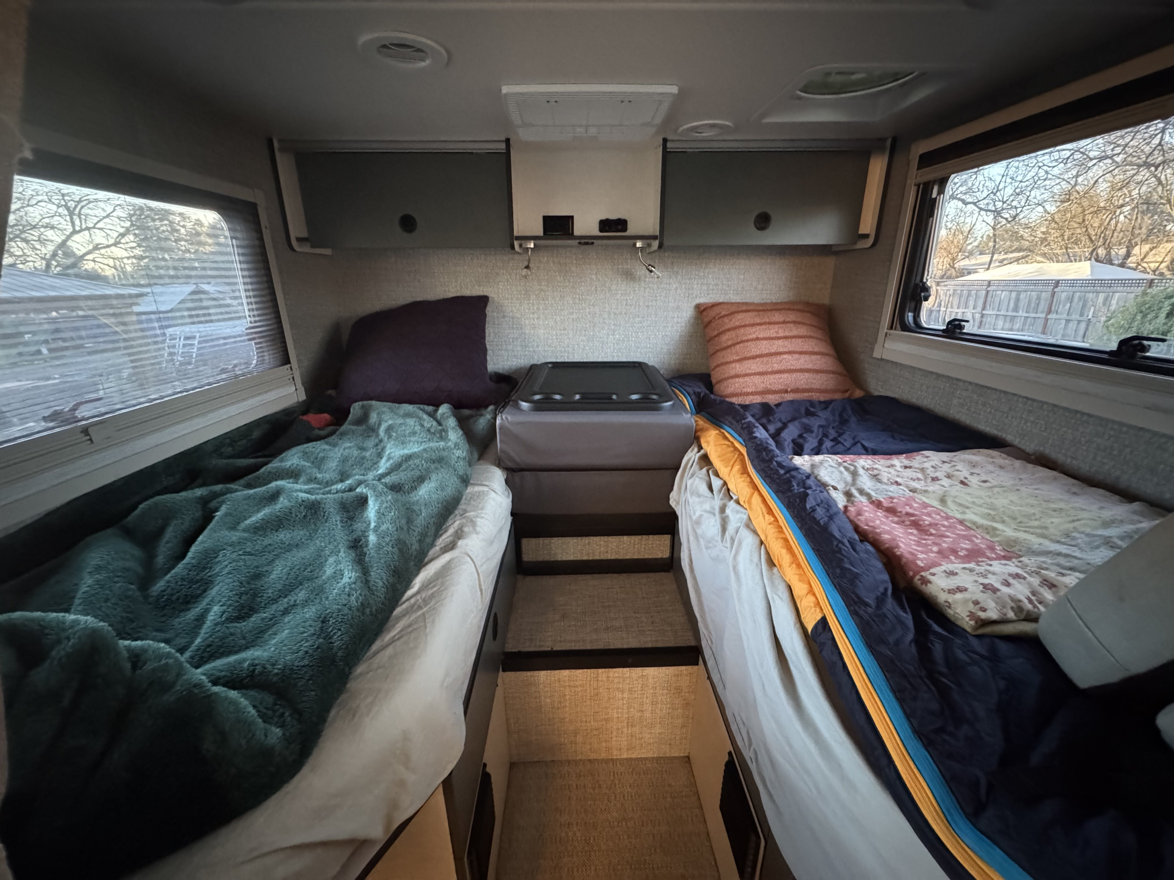 Comfortable rv rental interior features twin beds, overhead storage, & windows with outdoor views.. Winnebago Ekko 2024