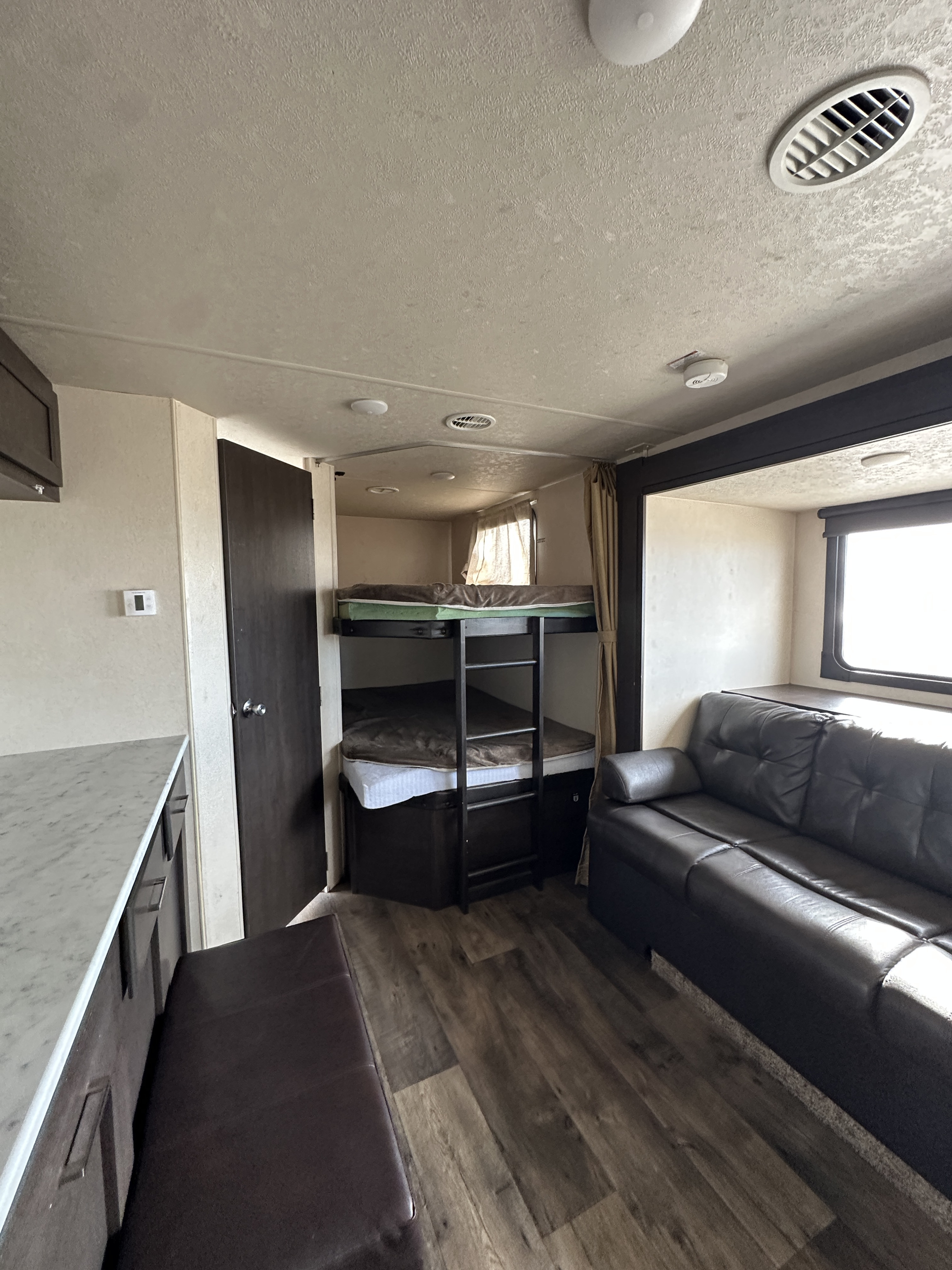 Spacious RV rental interior featuring bunk beds, a comfy couch, and kitchen counter, perfect for your next adventure.. Forest River Salem Cruise Lite 2019