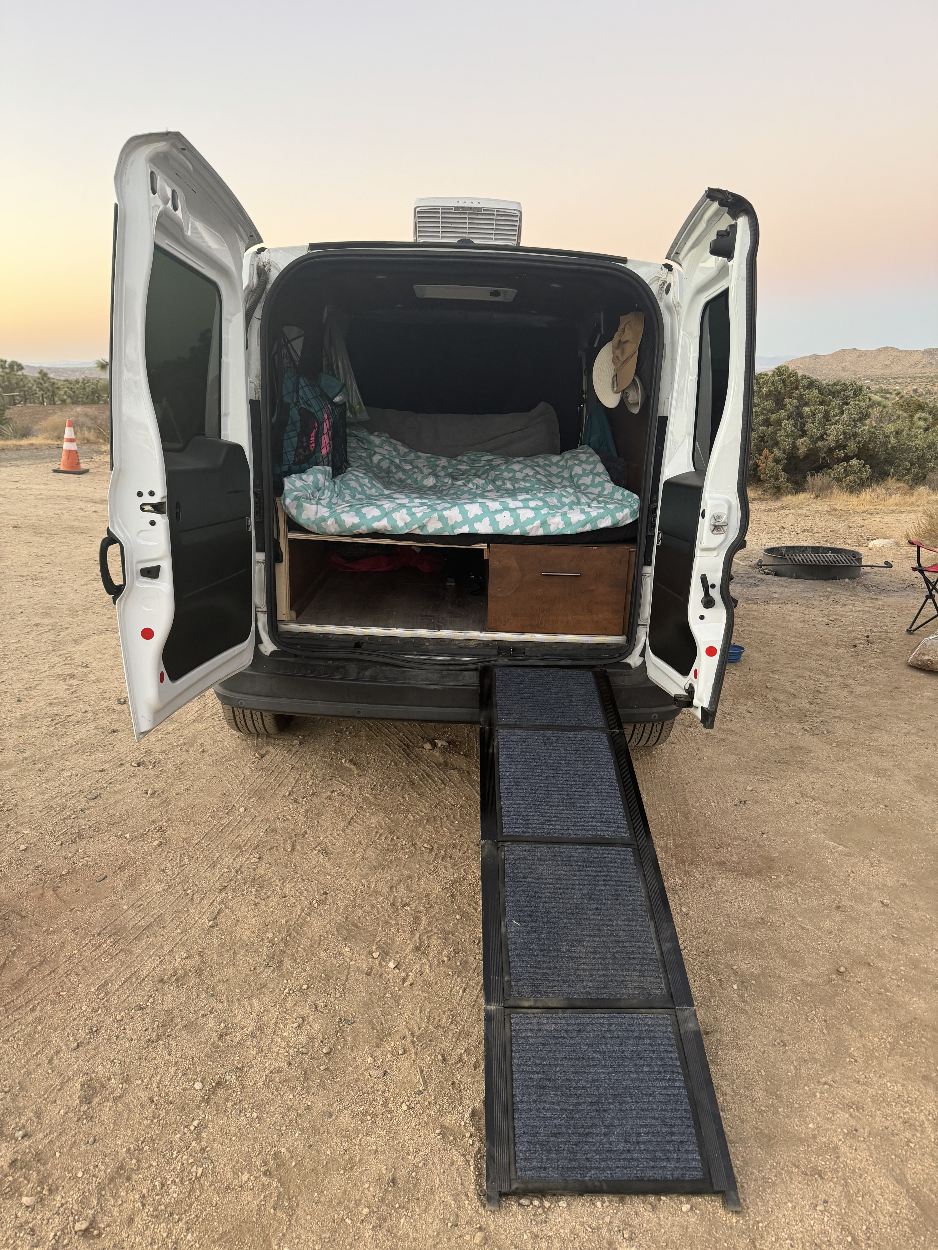 RV rental van with its back open, showing a bed, storage, and a ramp. Perfect for desert camping adventures.. Dodge RAM Promaster City 2017