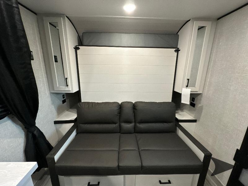 RV rental: Compact RV interior featuring a dark gray sofa, wall cabinets, and a clever integrated Murphy bed system.. Jayco Jay Flight 2024