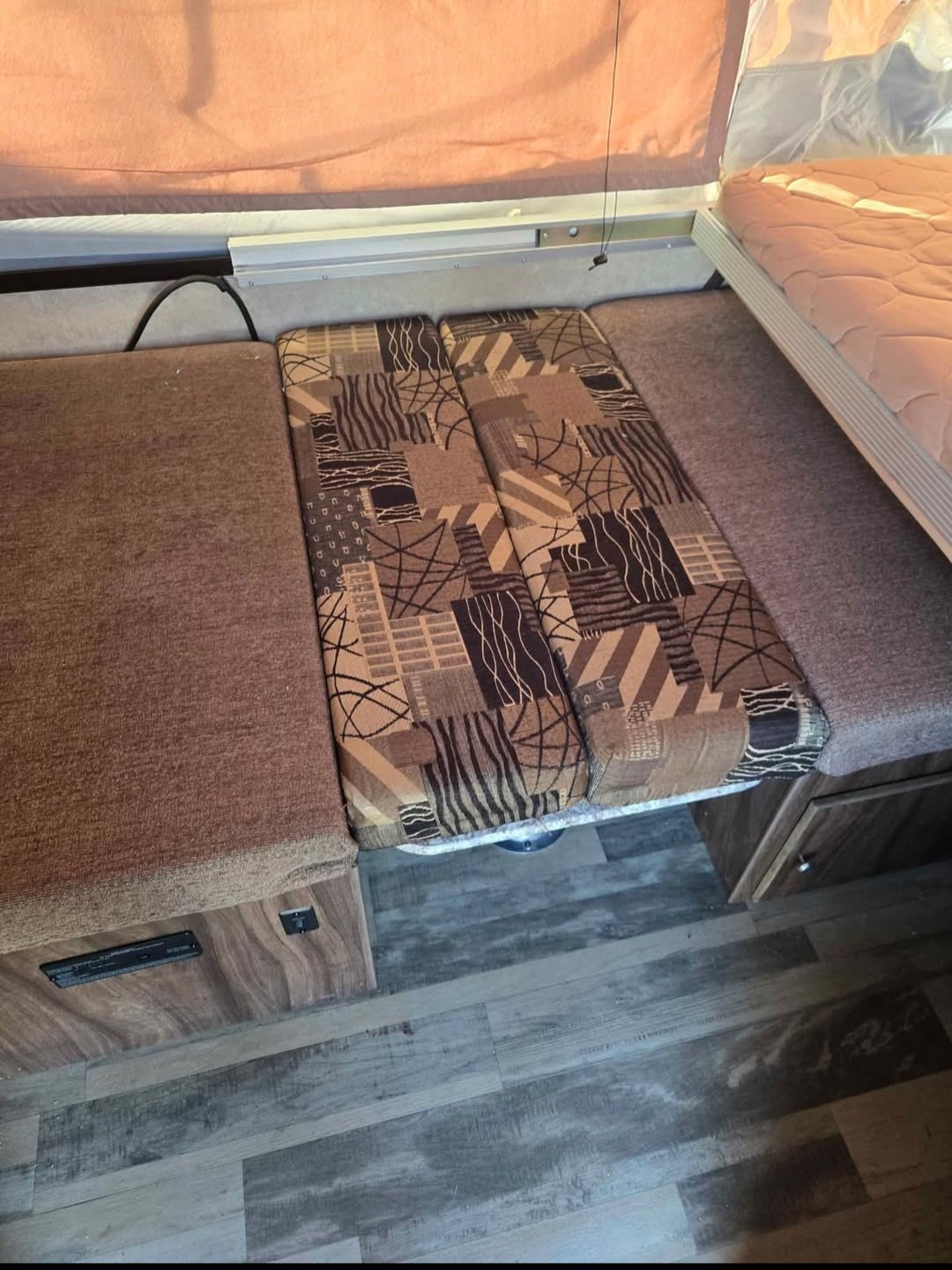 Cozy RV rental interior featuring a dinette area with brown and patterned cushions, convertible to a bed.. Coachmen Clip M128 2017