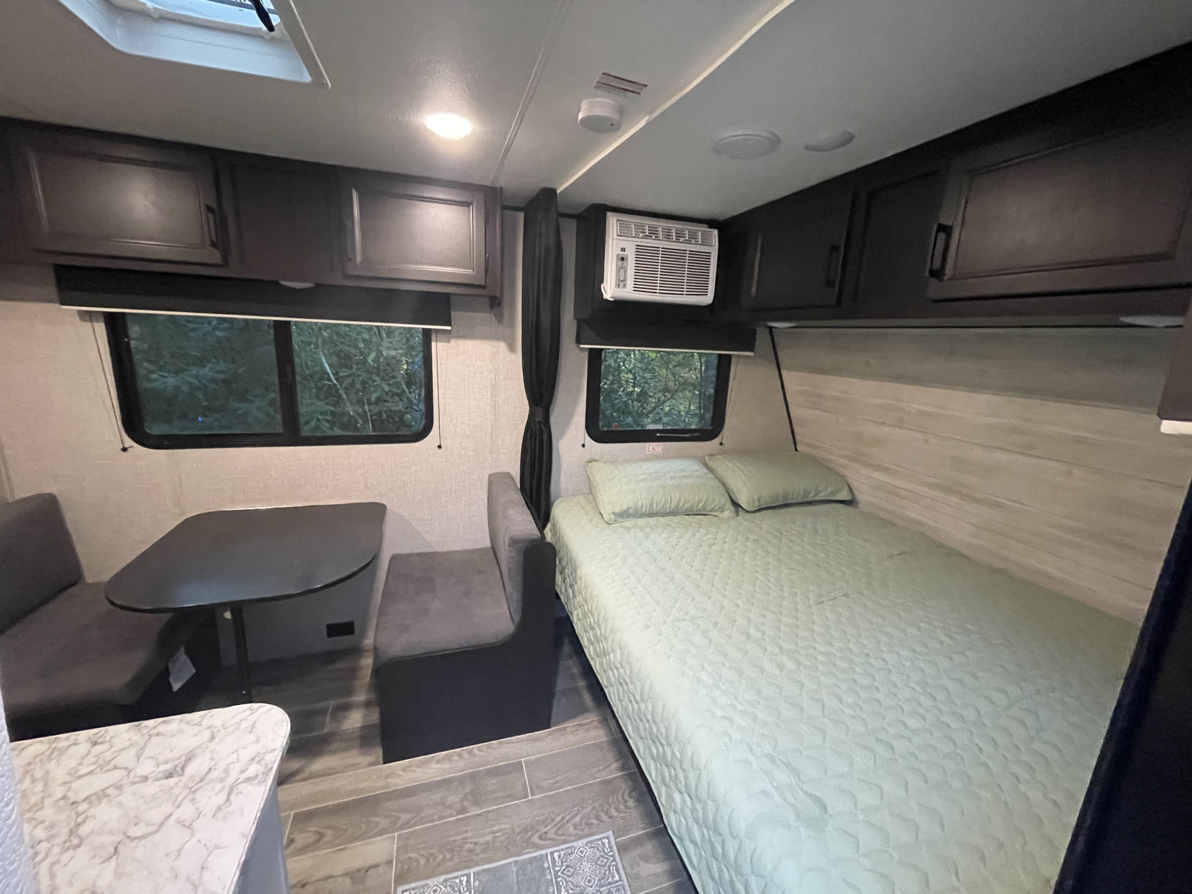 Inside a modern rv rental: a cozy bed, dinette, and ample storage. Perfect for your next adventure.. Jayco Jay Flight SLX 2022