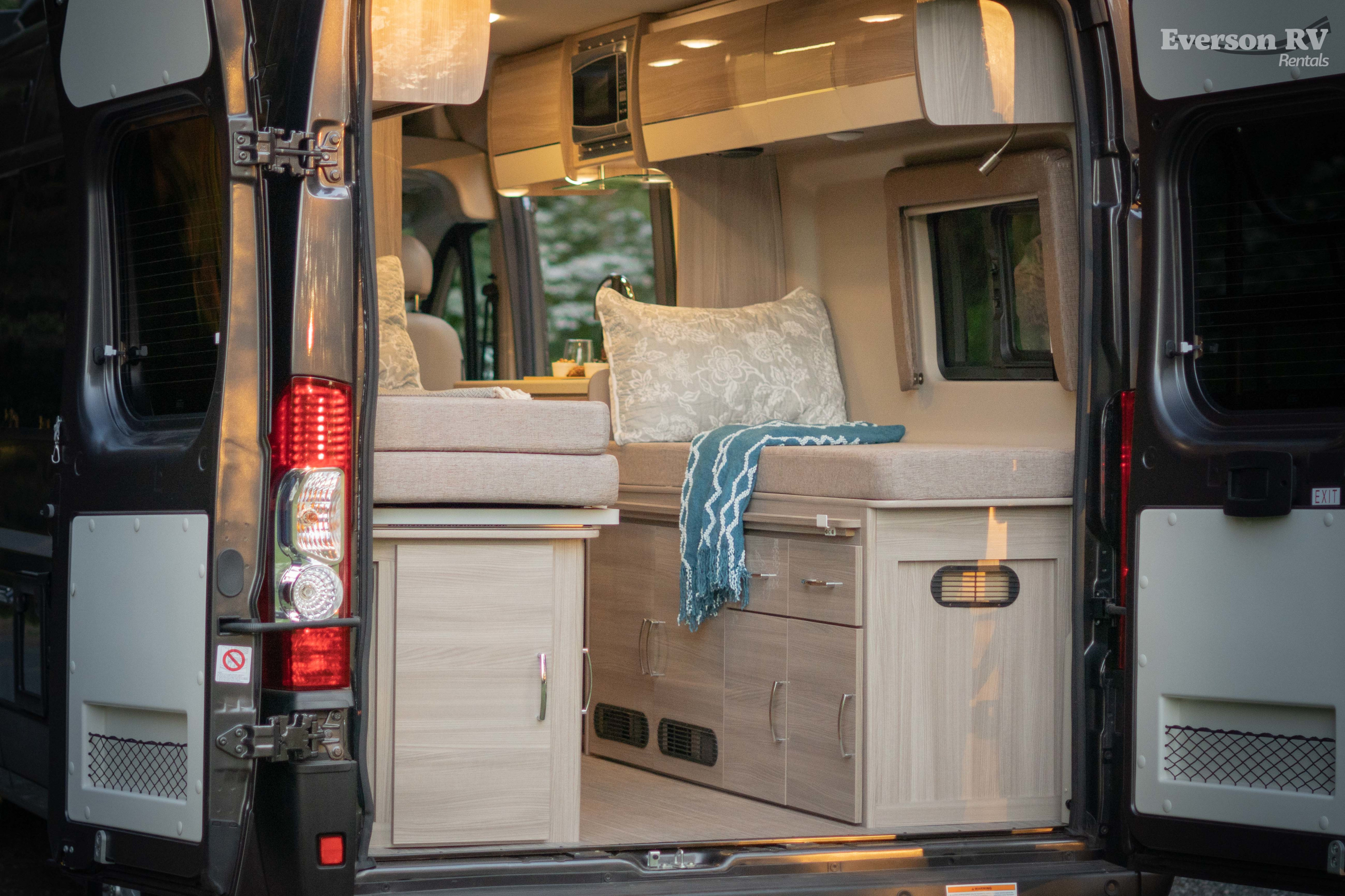 Cozy camper van interior visible through open RV doors, showcasing versatile living space for your rv rental adventure.. Thor Motor Coach Tellaro 2023