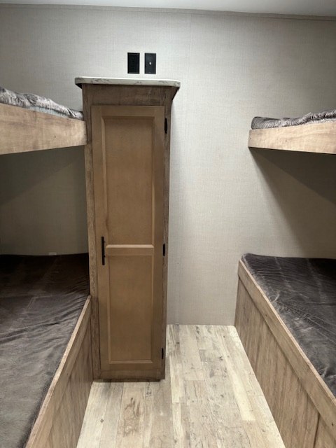 This RV rental bunkhouse features cozy sleeping for four with two bunk beds and a central storage cabinet.. Gulf Stream Innsbruck 2023