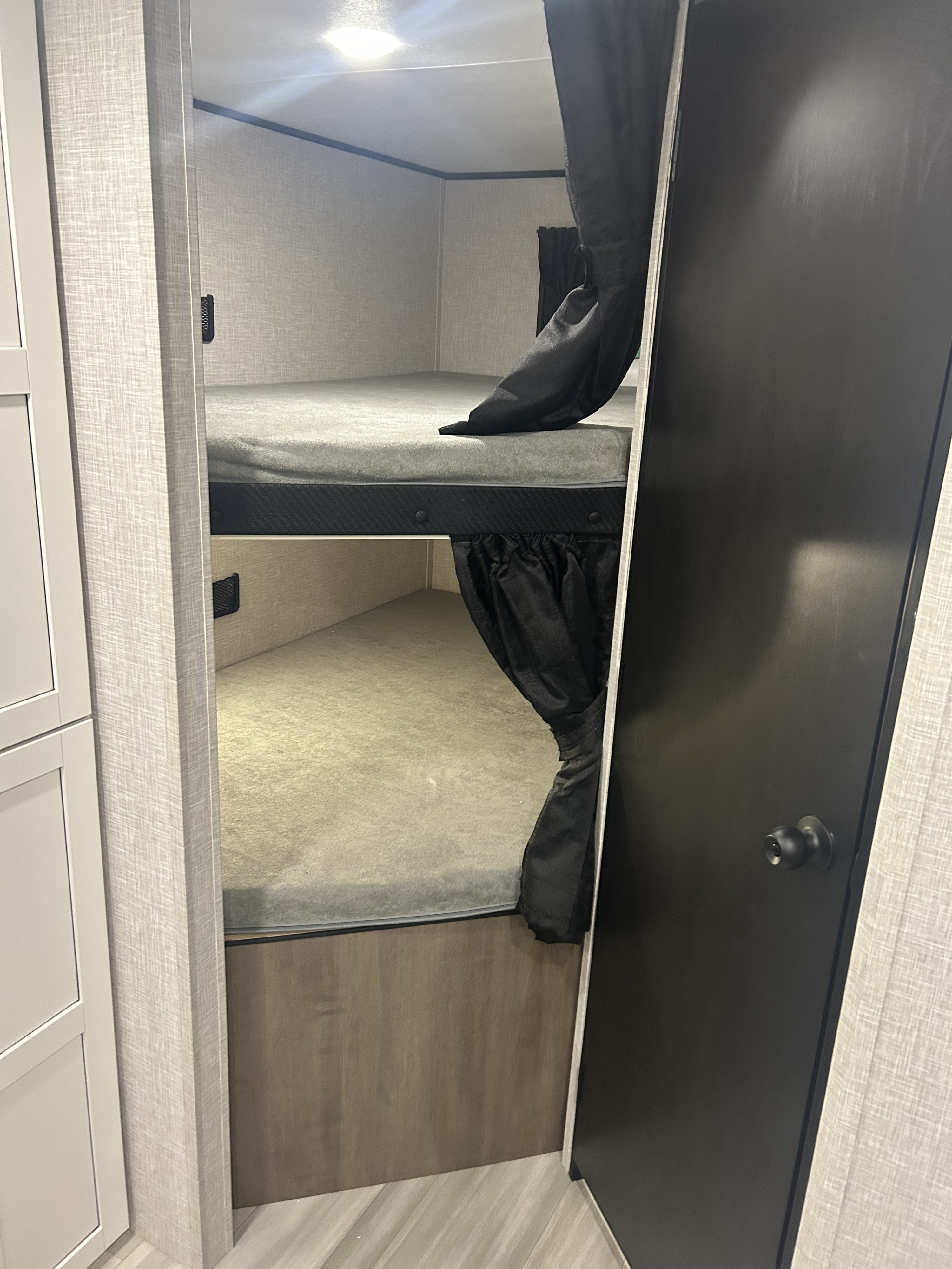 Cozy bunk beds with privacy curtains in an RV rental, providing a compact and functional sleeping area.. Highland Ridge Wayfinder GoPlay 26BHS 2025