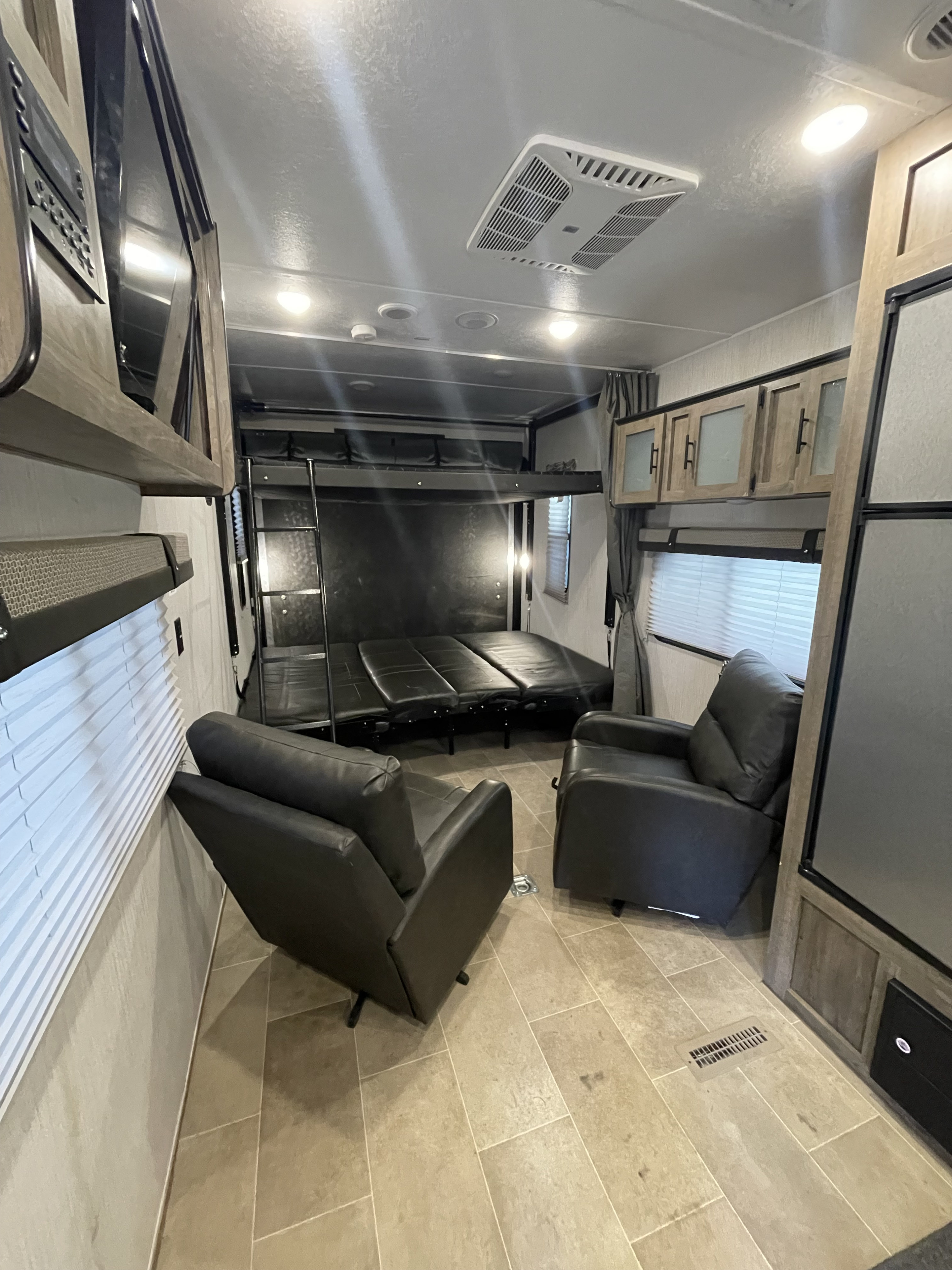RV rental interior: Flexible space with fold-down beds, two recliners, AC, and storage cabinets.. Palomino Puma 2021