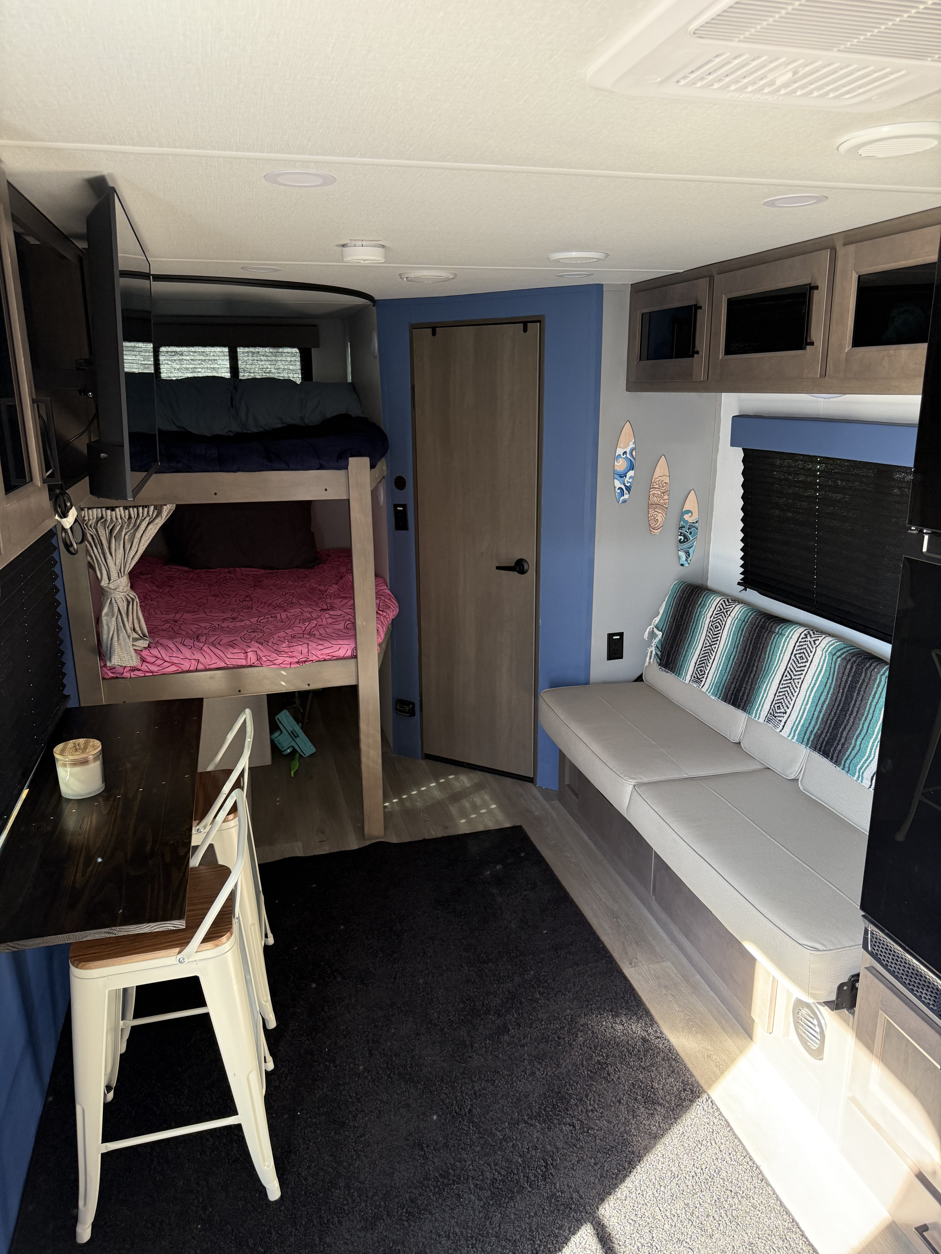 RV rental interior: Bunk beds, a dining table, and sofa define this functional living space.. Grand Design Transcend Xplor 2024