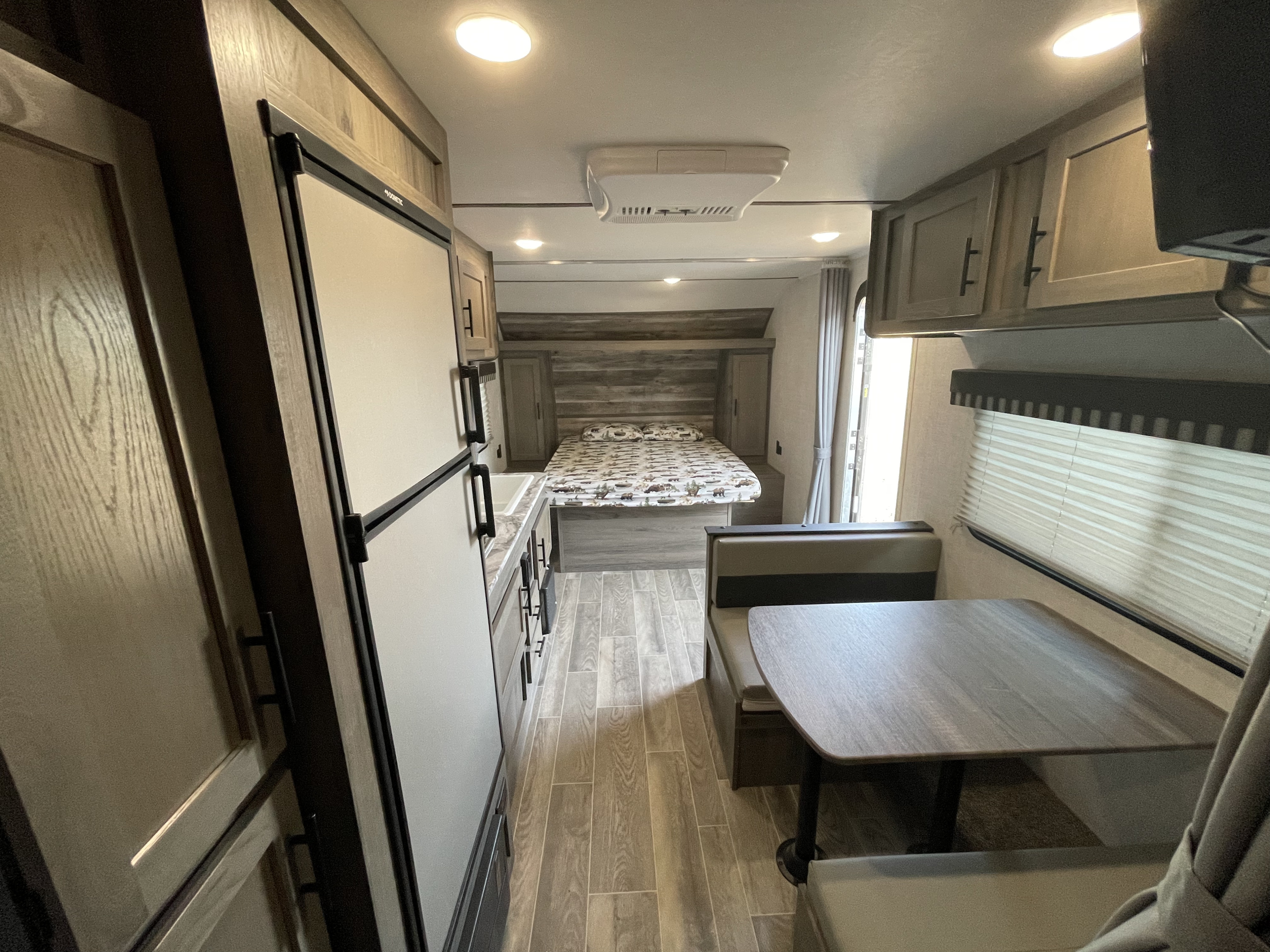 RV rental interior: A bright, modern living space featuring a bedroom, compact kitchen, and inviting dinette.. Gulf Stream Enlighten 2021