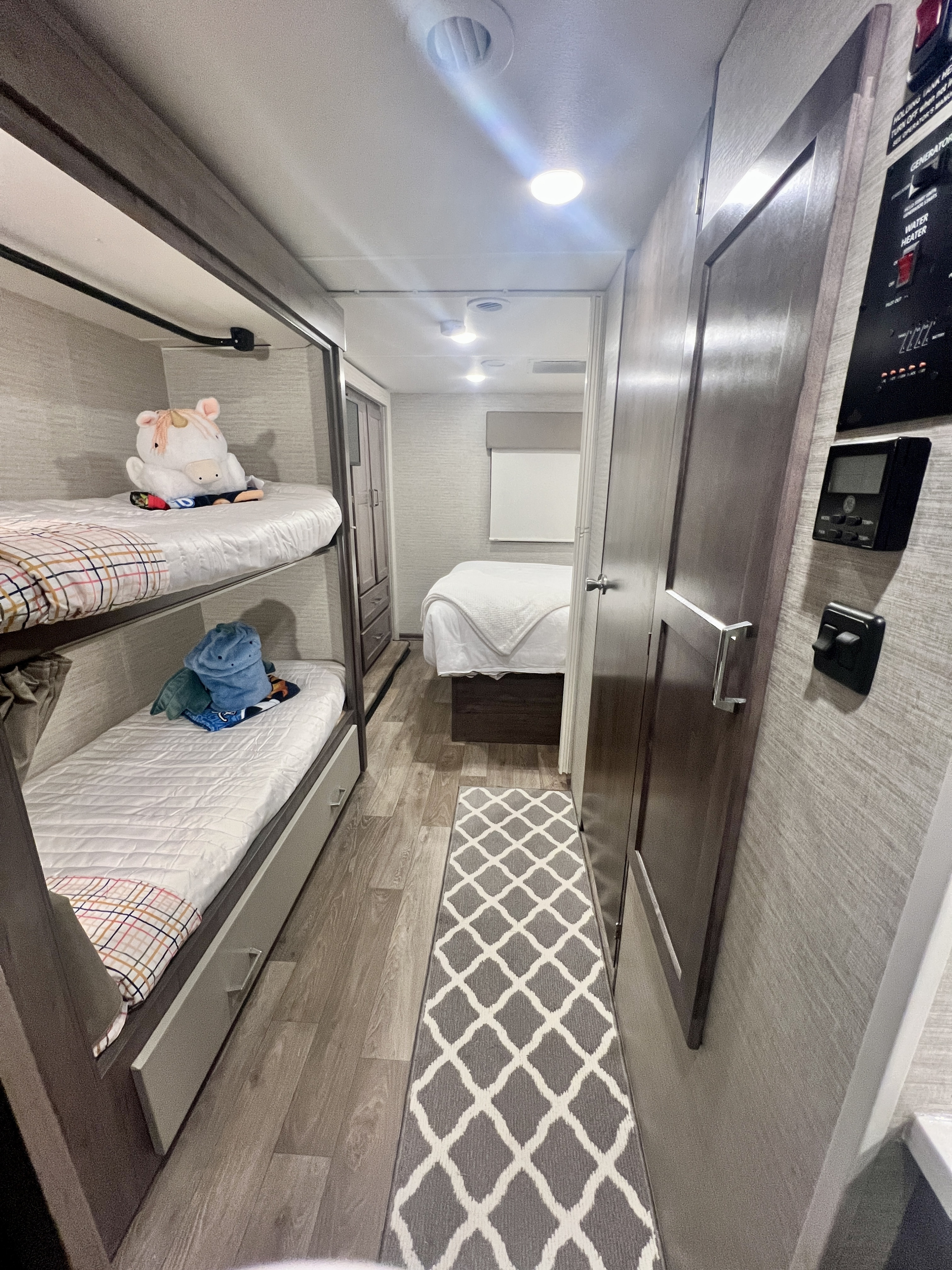 RV rental interior featuring bunk beds, a hallway with a runner rug, and a master bedroom area.. Winnebago Spirit 2025