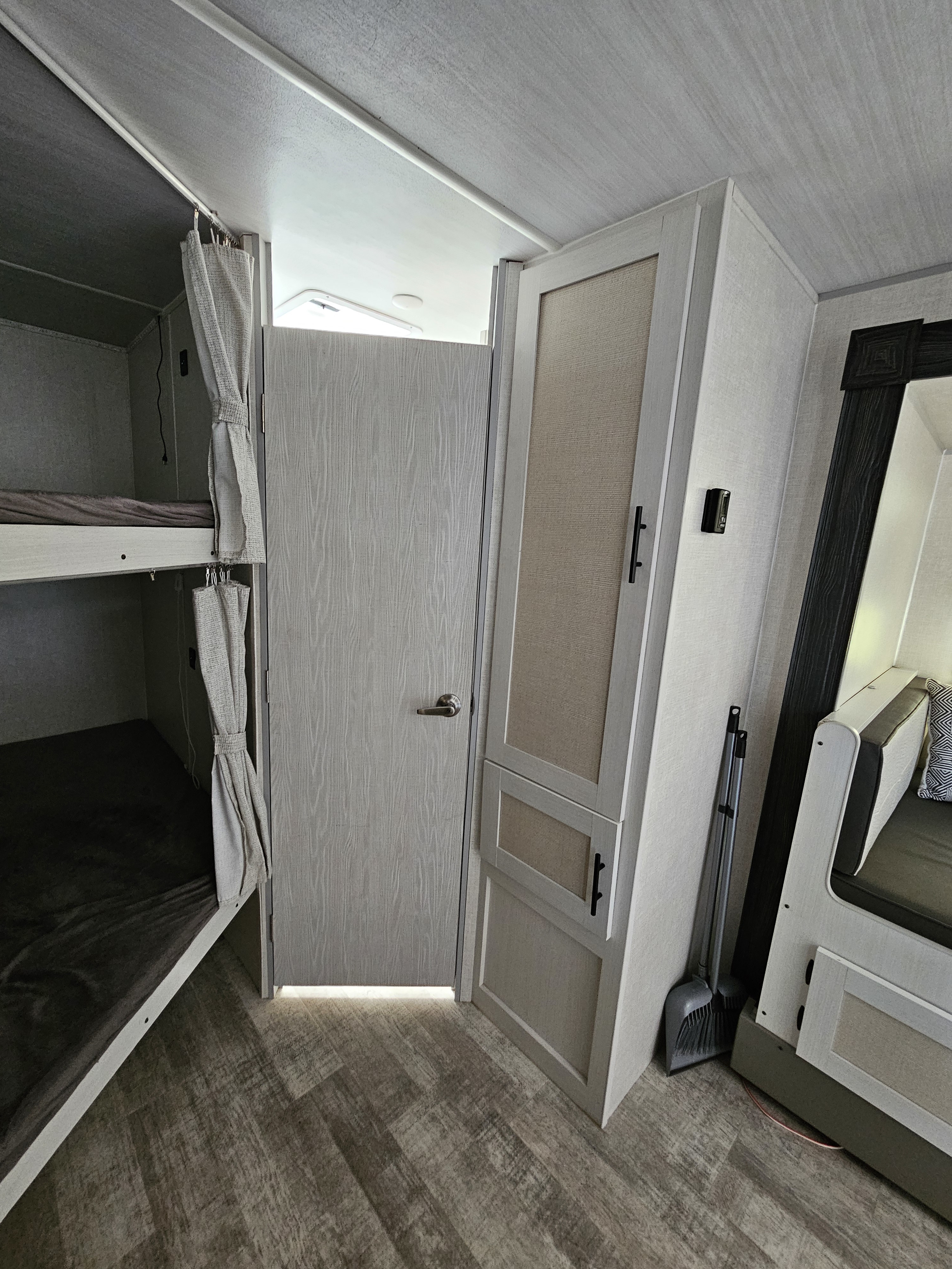 RV rental interior features: bunk beds with privacy curtains, a door, and compact storage cabinetry.. Forest River No Boundaries NB20.3 Essentials Only 2023