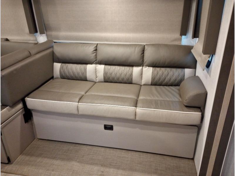 This RV rental's light grey sofa with quilted backrests offers comfortable living area seating.. Forest River Wildwood 2023