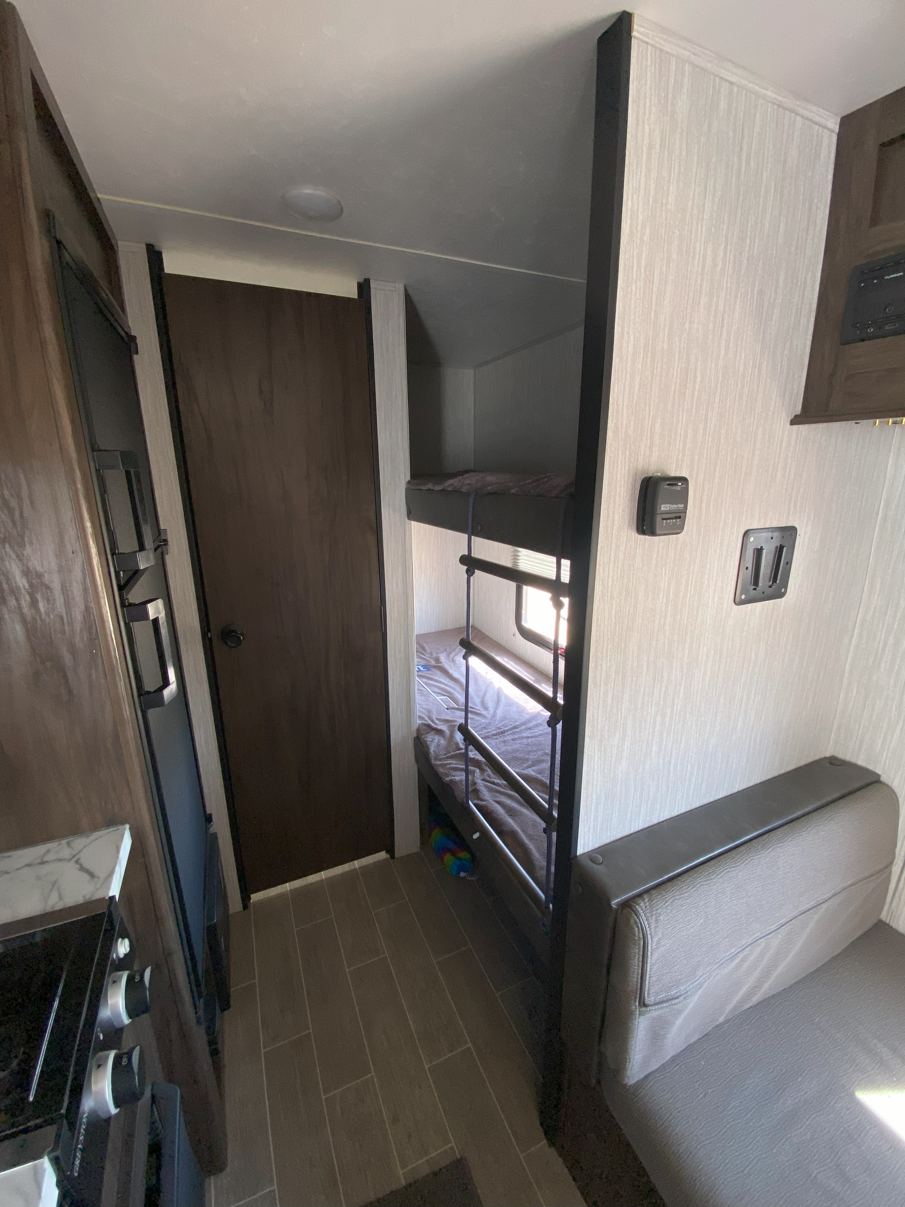 RV rental interior showcasing bunk beds, kitchen counter with stove, and comfortable dinette seating area.. Forest River Cherokee Wolf Pup 2020