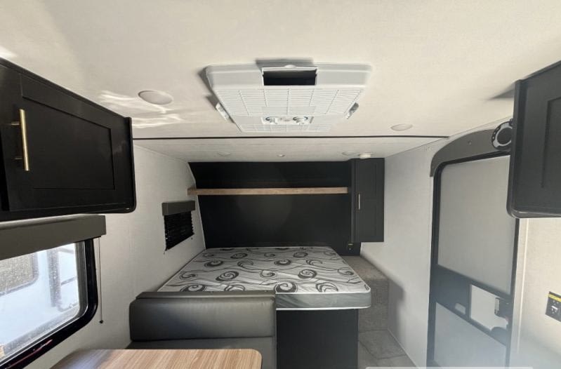 Inside this RV rental: full bed, dinette, overhead cabinets, and AC unit. Ready for your adventure!. Keystone RV Springdale 2023