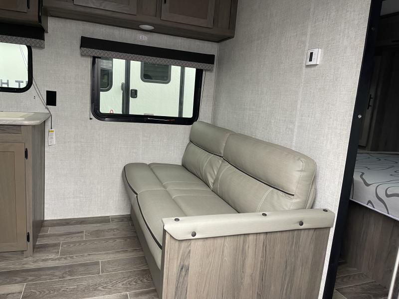 Inside this modern **rv rental**, find a light gray sofa, wood-look flooring, windows with shades, and a glimpse of the bedroom.. Gulf Stream Innsbruck 2022