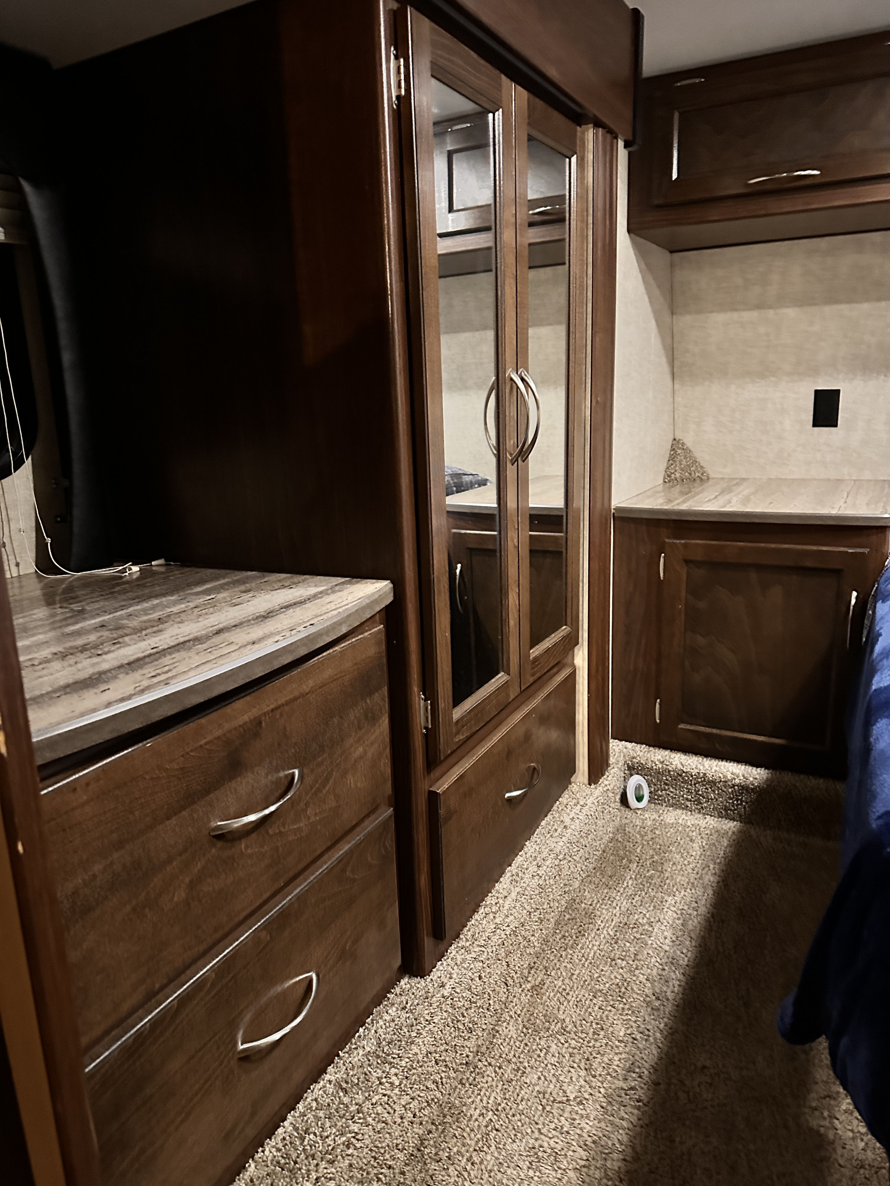 RV rental bedroom interior with dark wood cabinetry, mirrored closet, and plush carpet.. Heartland Torque 2015