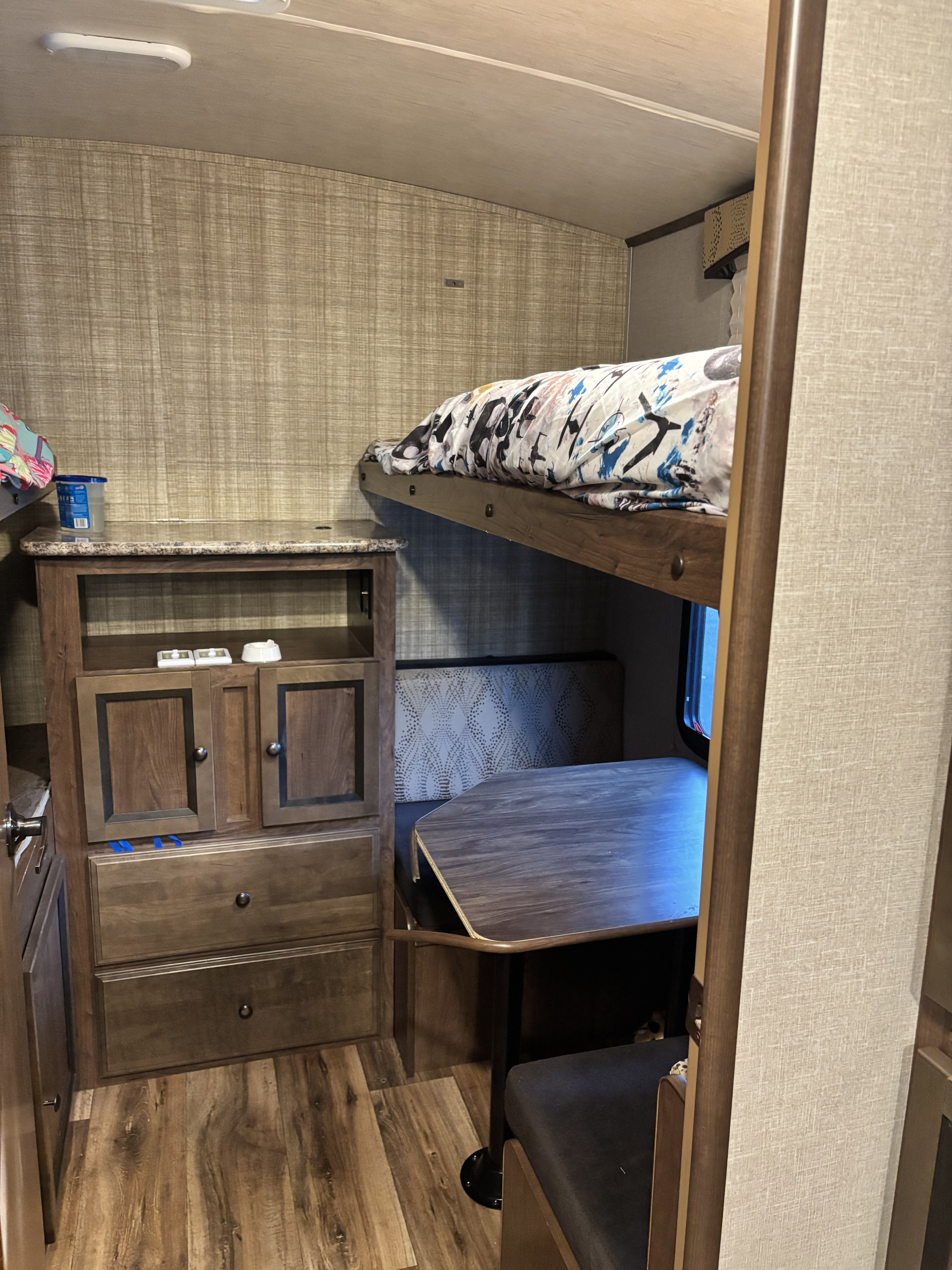 RV rental interior showing a bunk bed, dinette with table & bench, and wooden storage cabinets.. Cruiser Rv Corp Cruiser 2017