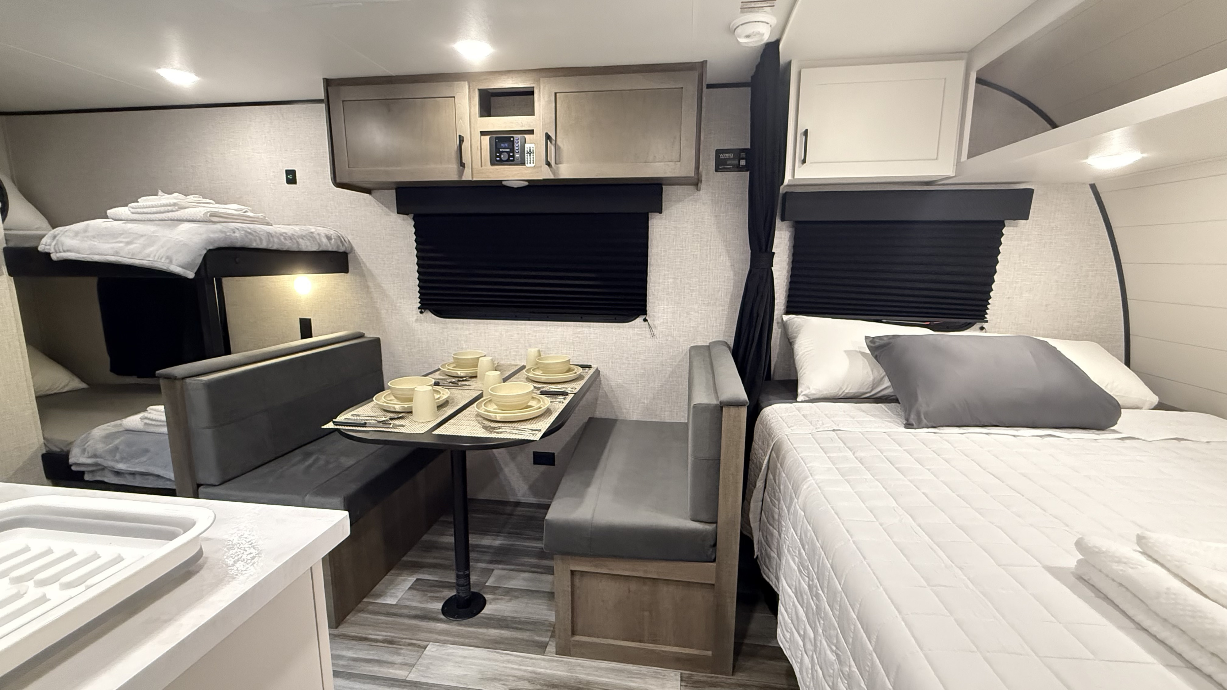 Spacious RV rental interior with a cozy dinette, main bed, and bunk beds, offering comfort for your adventures.. Jayco Jay Flight SLX 175BH 2025