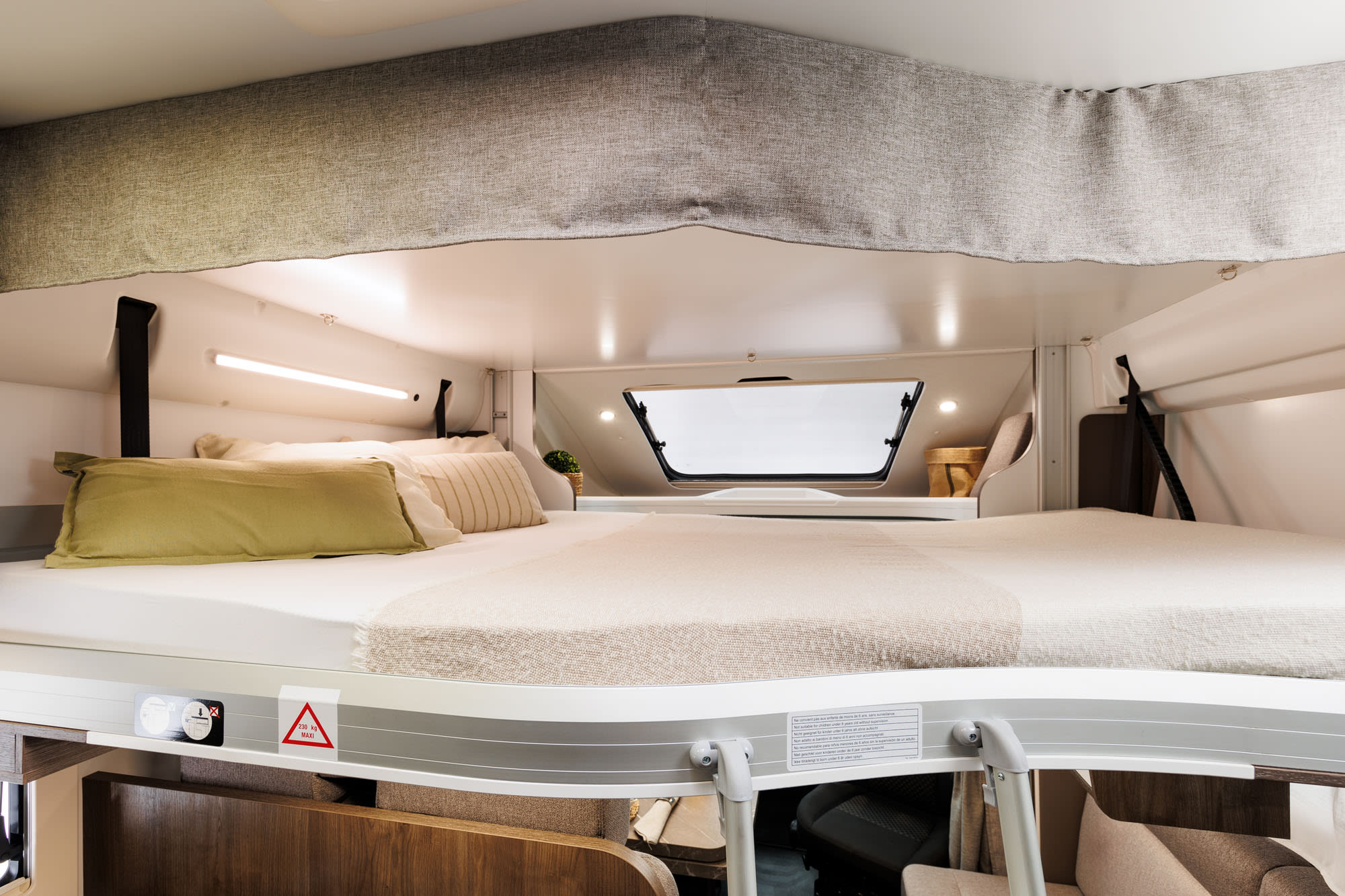 Cozy RV rental bunk bed with pillows and blanket, showing a bright camper interior sleeping area and window.. Benimar Tessoro 463UP 2025