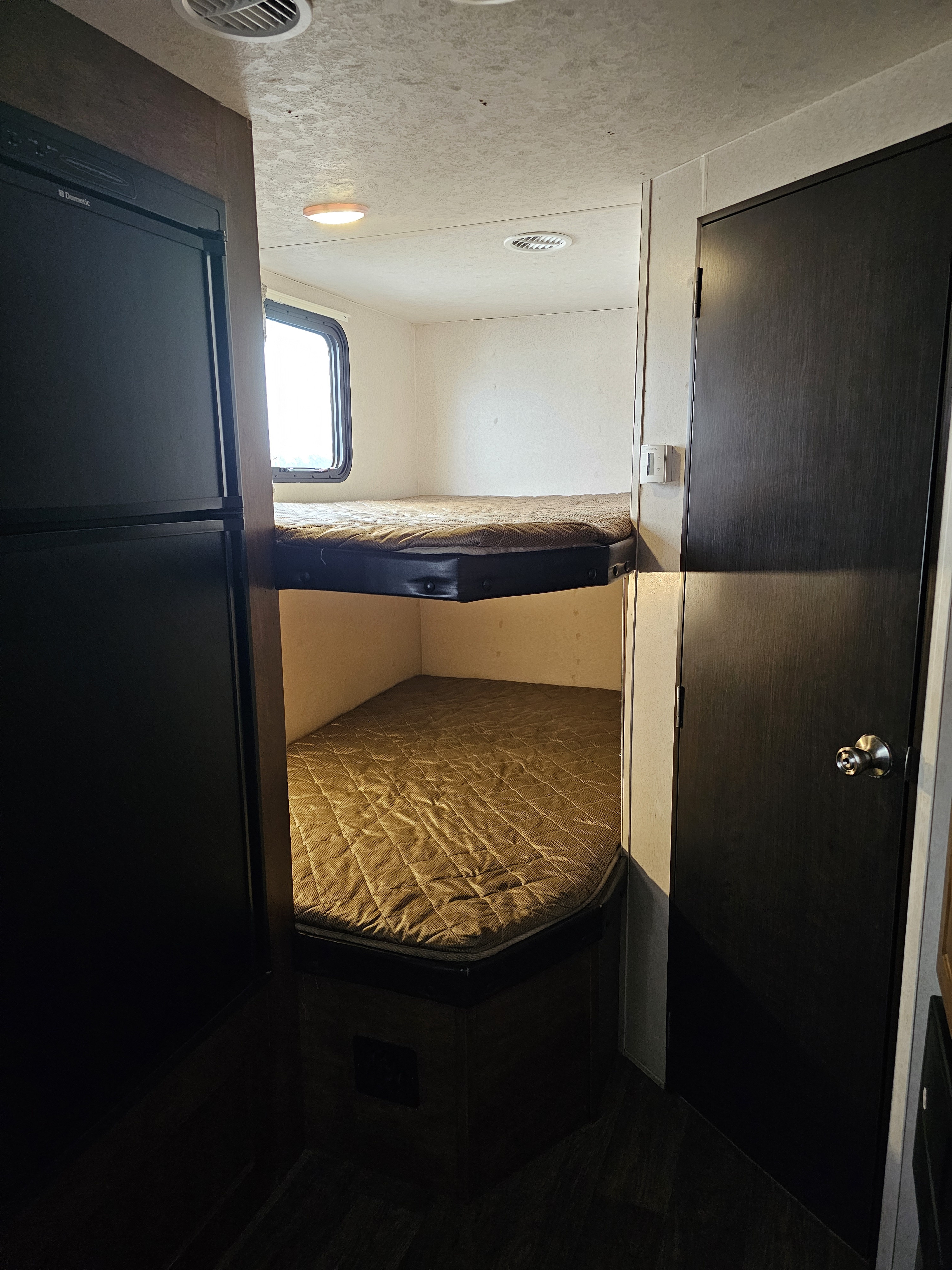 Cozy RV rental interior featuring comfortable bunk beds and compact living space, perfect for your next adventure.. Forest River Wildwood X-Lite 2018