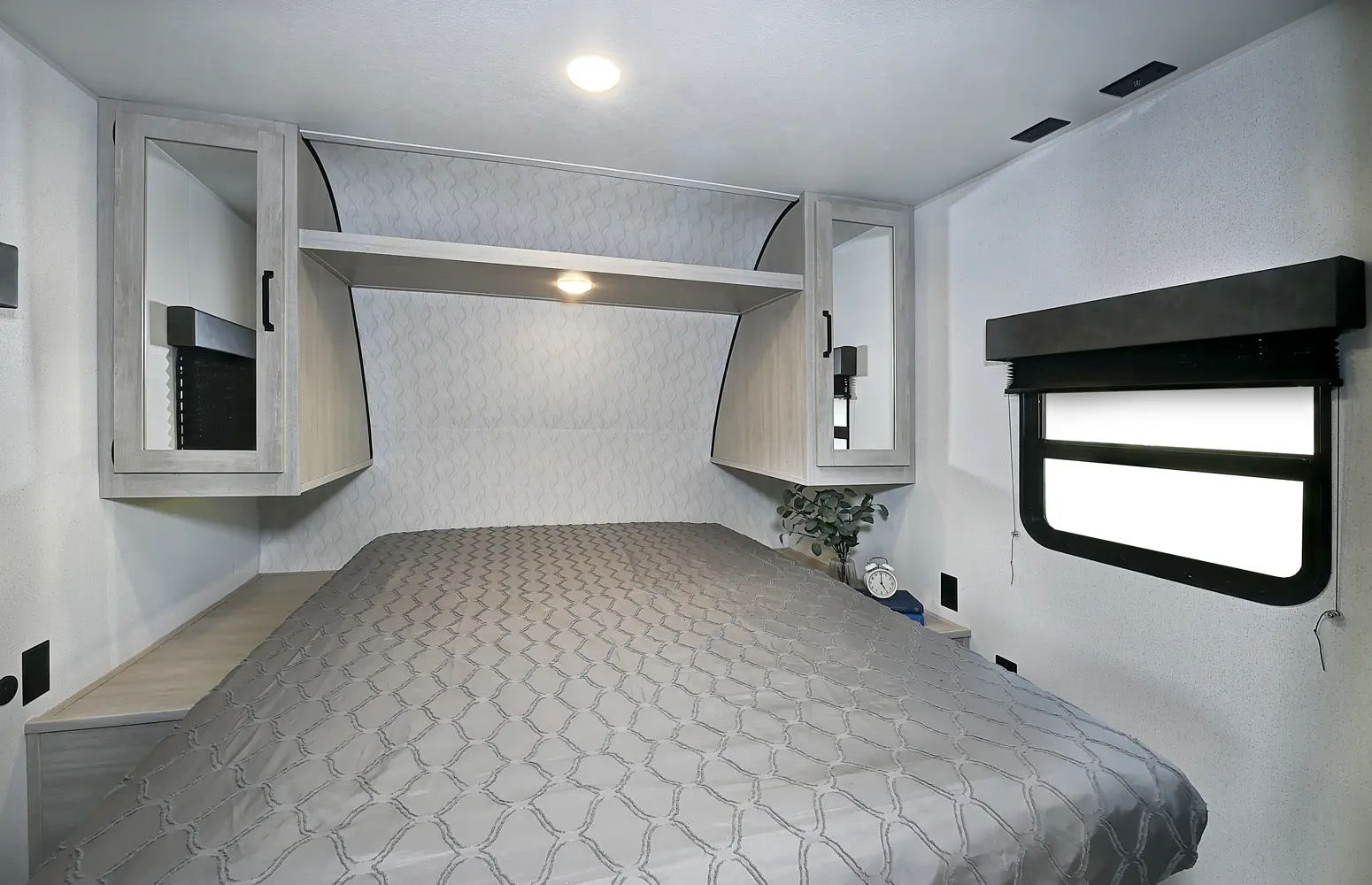 Comfortable RV rental bedroom with a large bed, overhead cabinets, and a window, designed for restful travel and ample storage.. Palomino Puma 283BHCE 2025