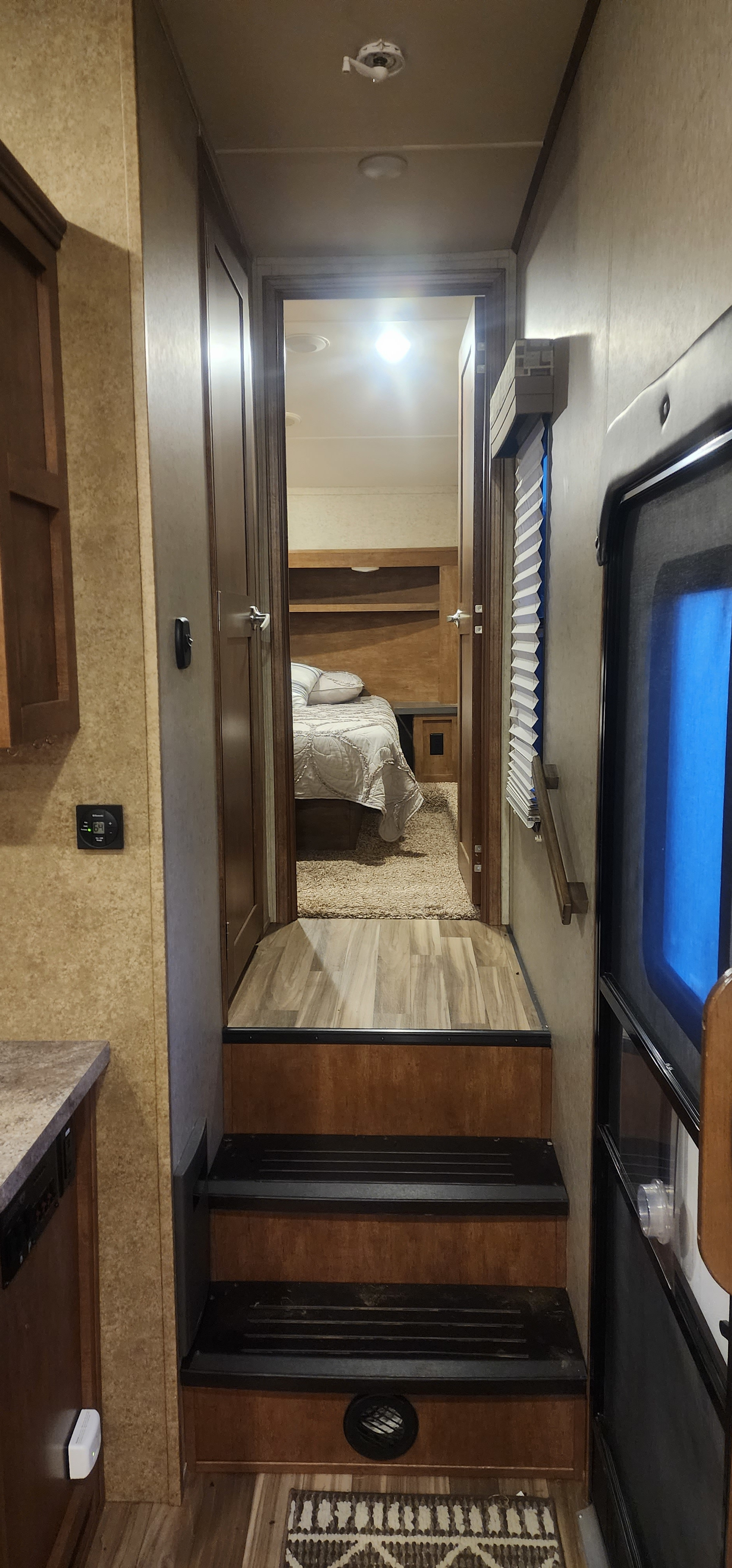 RV rental interior: A cozy bedroom hallway with stairs and a view of the bed. Shows wood paneling and practical features.. Forest River Sabre Sabre Lite 2016