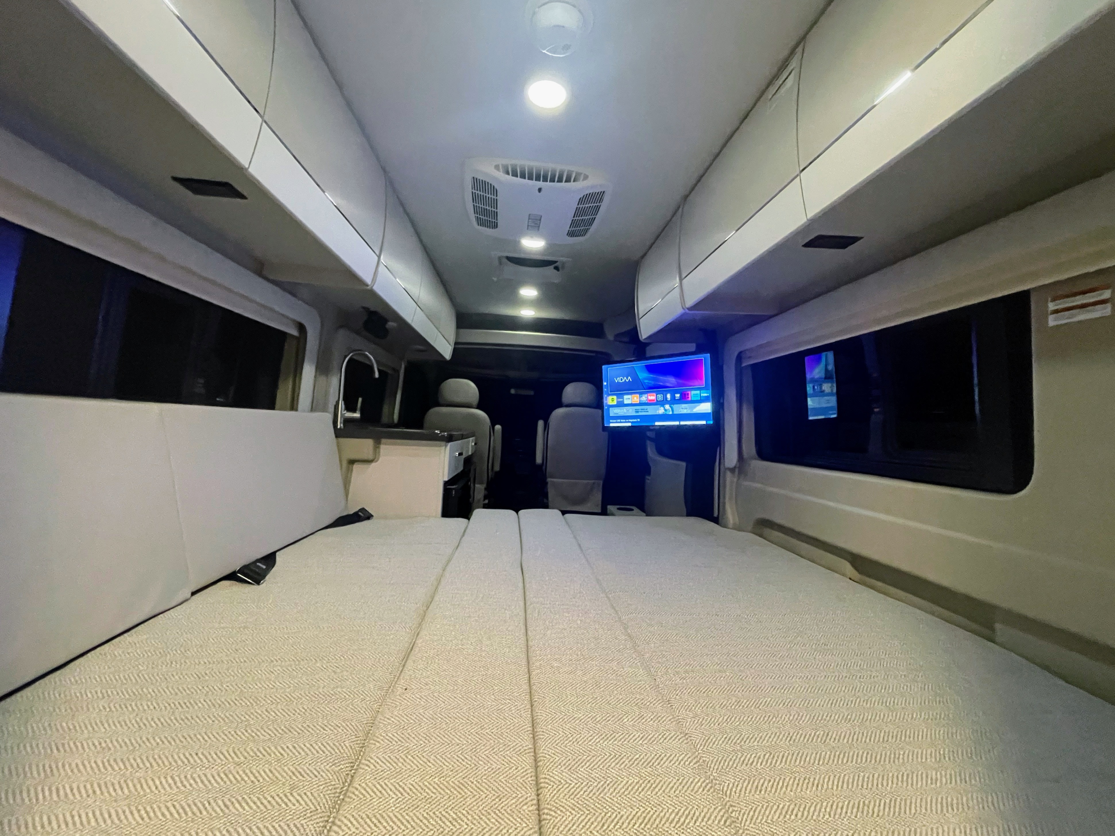 RV rental interior: convertible bed, kitchenette, TV, and overhead storage for comfortable mobile living.. Entegra Ethos 20T 2025