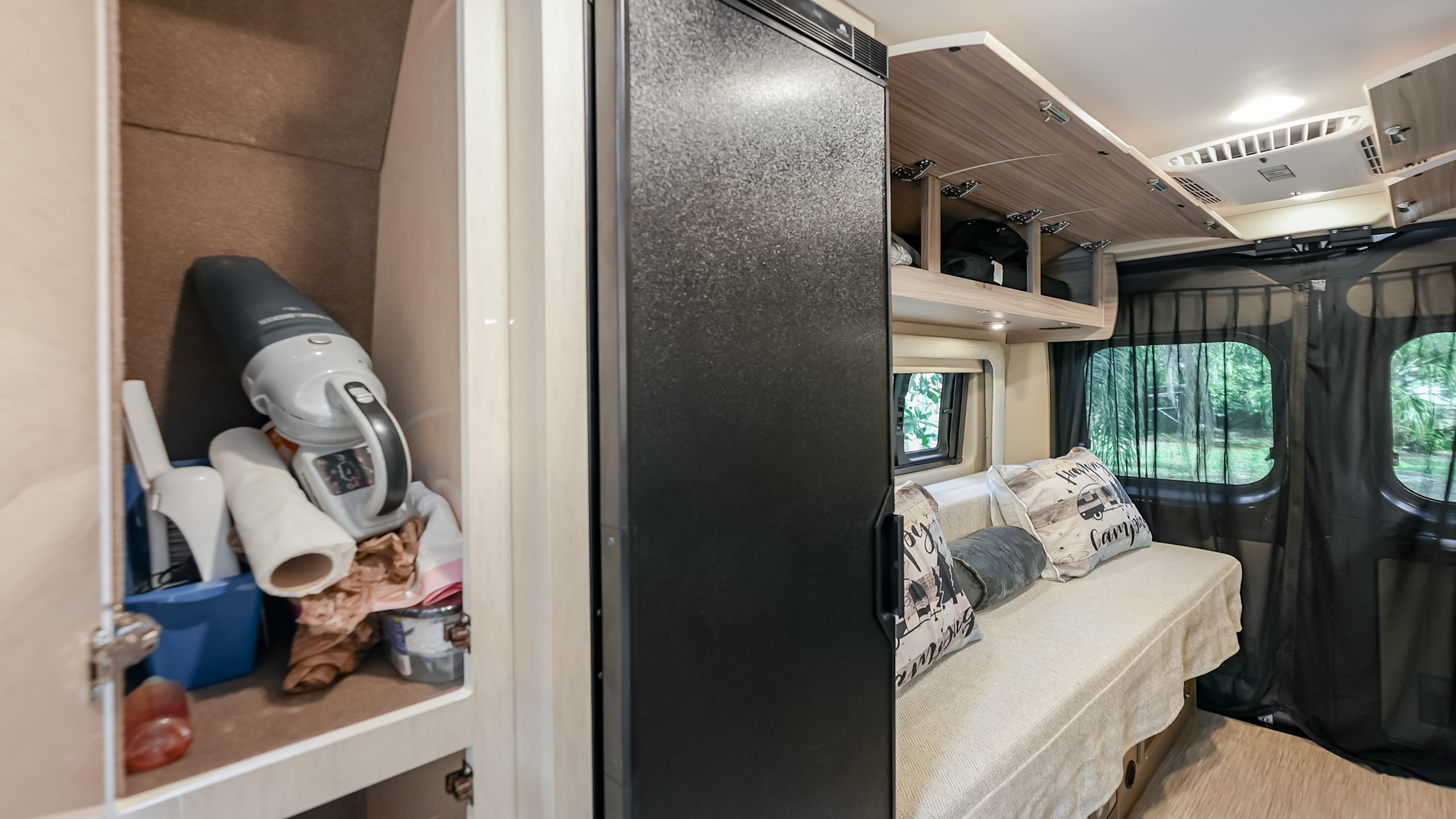 RV rental interior: organized compact living space with a full-size fridge, overhead storage, and a well-stocked utility cabinet.. Jayco swift 2024