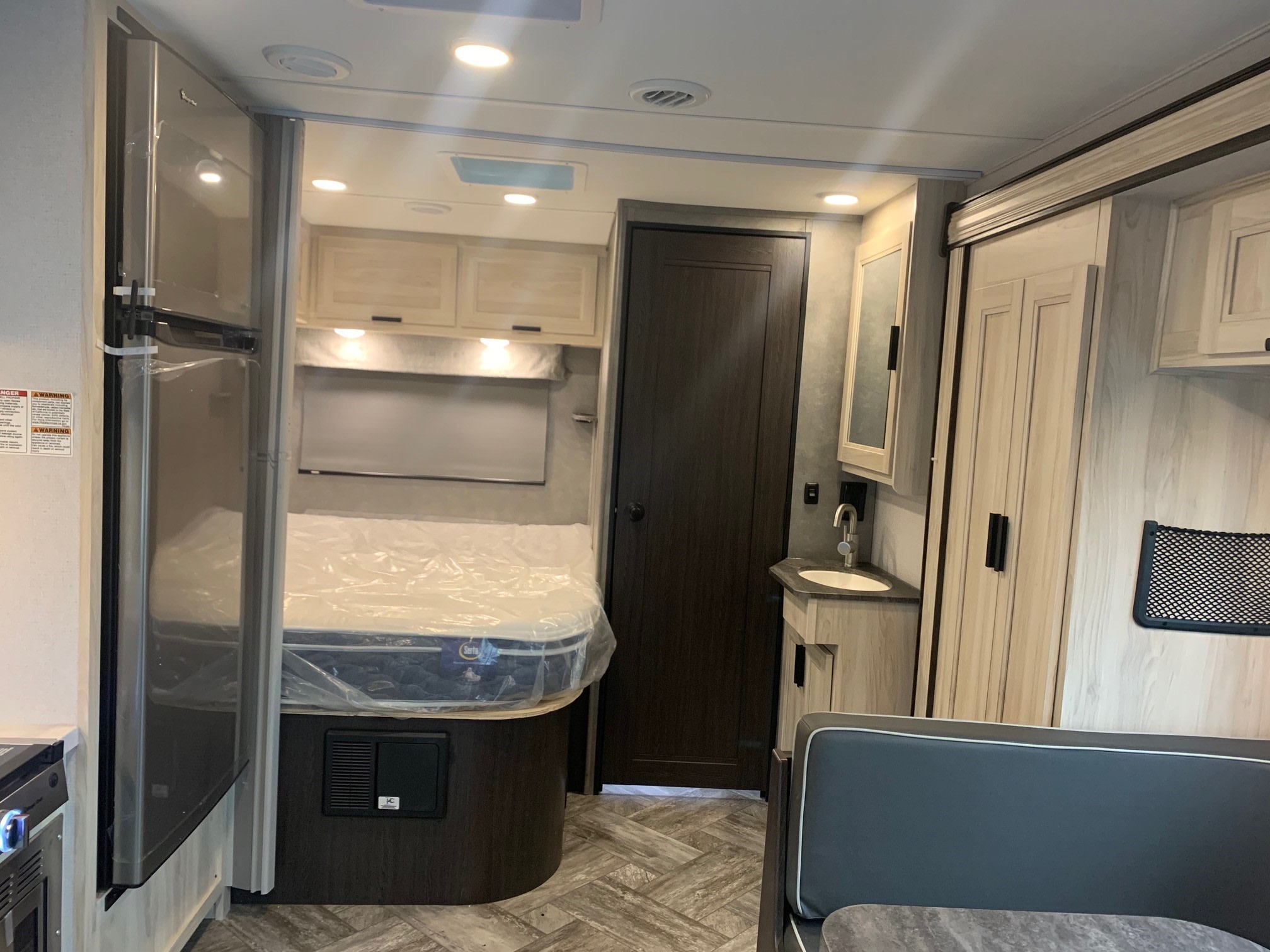 RV rental interior: A compact bedroom with a new mattress, sink vanity, and comfortable living area for travel.. Forest River Sunseeker 2026