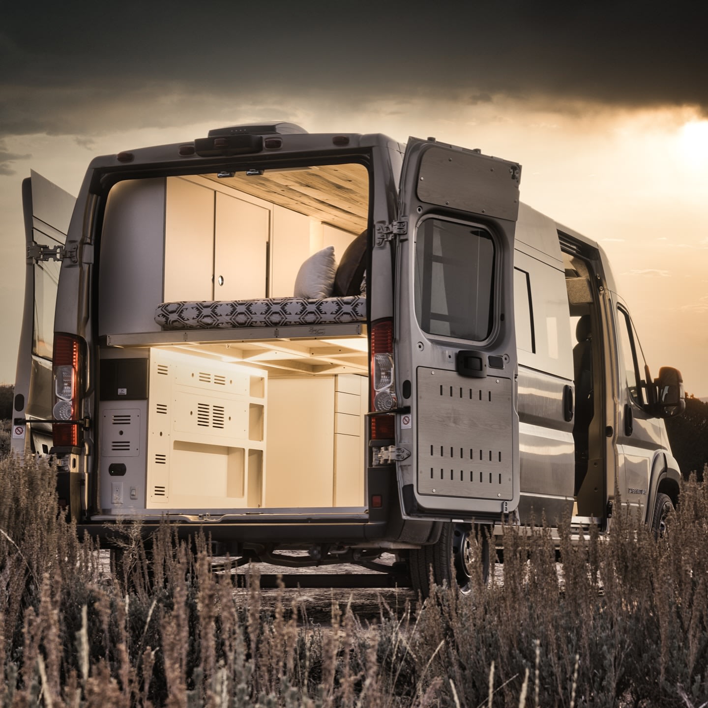 This RV rental camper van showcases a comfortable interior with bed & storage, ready for your next outdoor adventure.. Dodge Ram 1500 2024